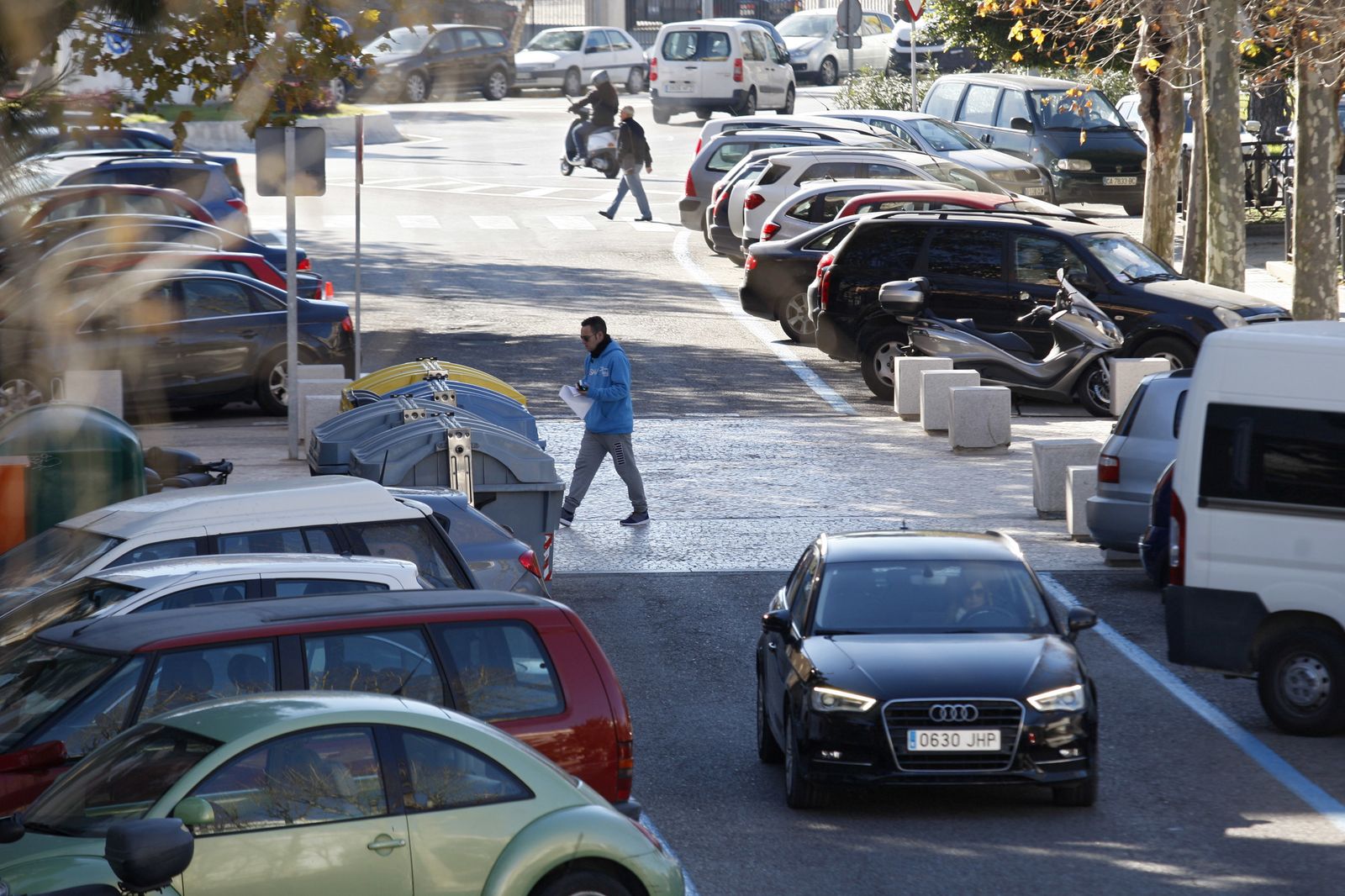 Un coche circula entre los que se encuentran estacionados en la zona donde está el edificio de la Junta de Andalucía.
