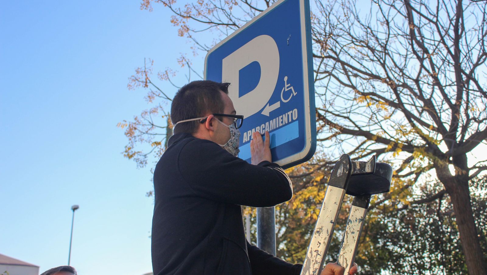 Un miembro de Down Córdoba tapa el término "minusválido" de una señal.