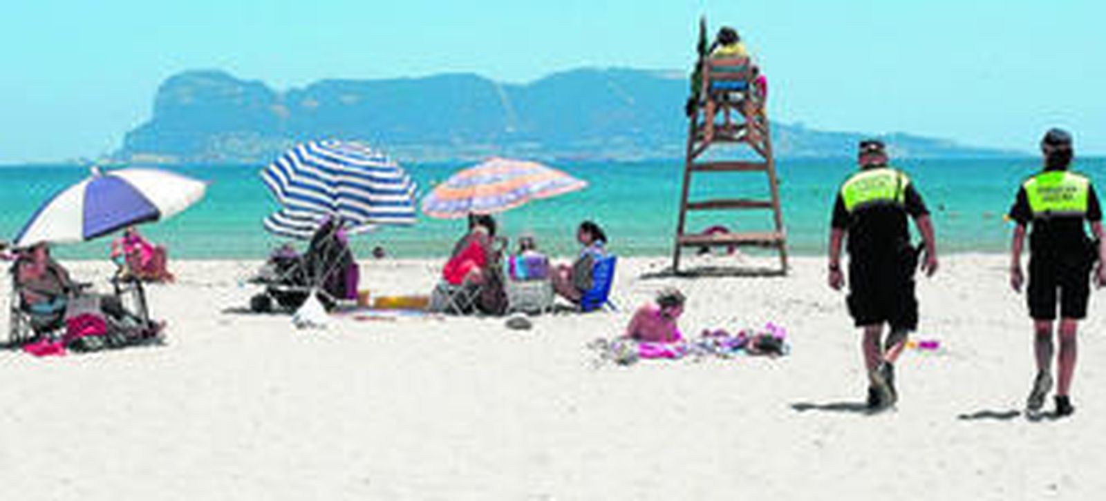 Imagen de la playa de El Rinconcillo con la presencia de dos agentes vigilando el viernes por la mañana.