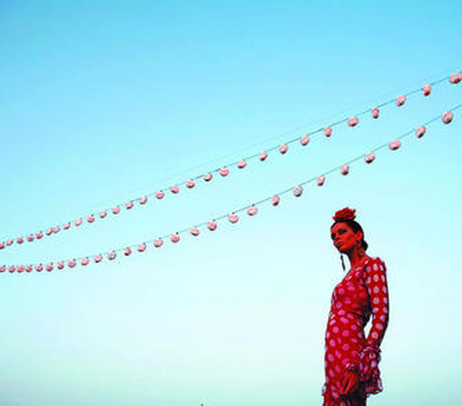 Una modelo desfila vestida de flamenca en un pase profesional.