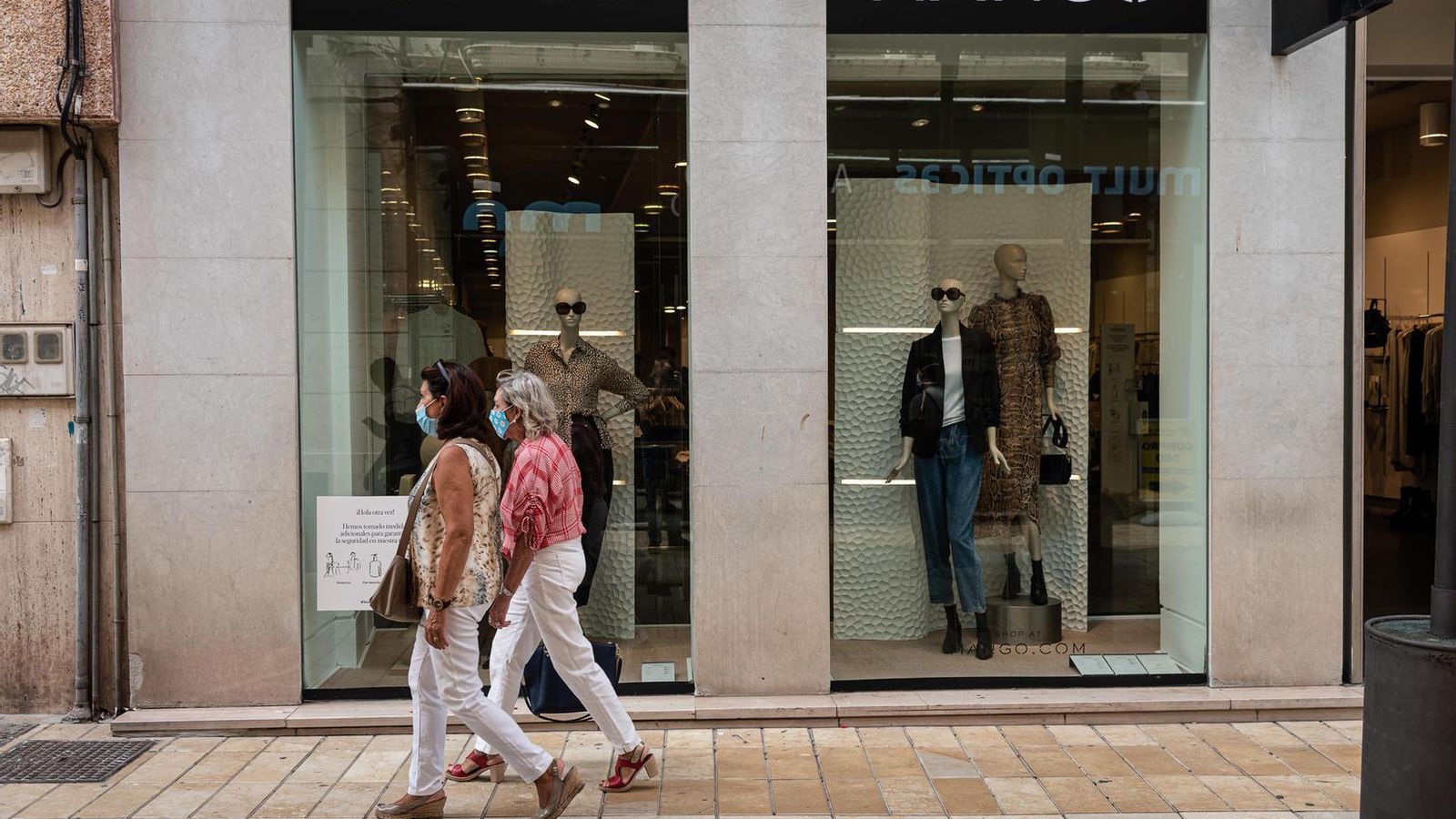 Dos mujeres pasan por delante de unos escaparates de una firma de moda.