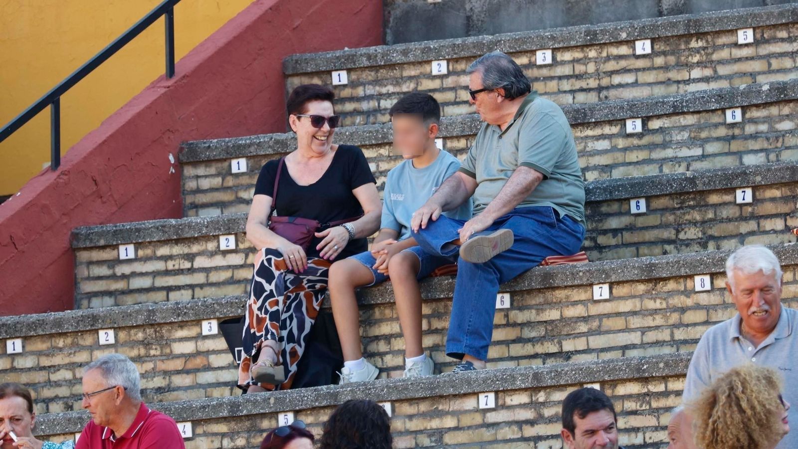 Un niño en el tendido de la plaza de toros de Algeciras junto a unos familiares.