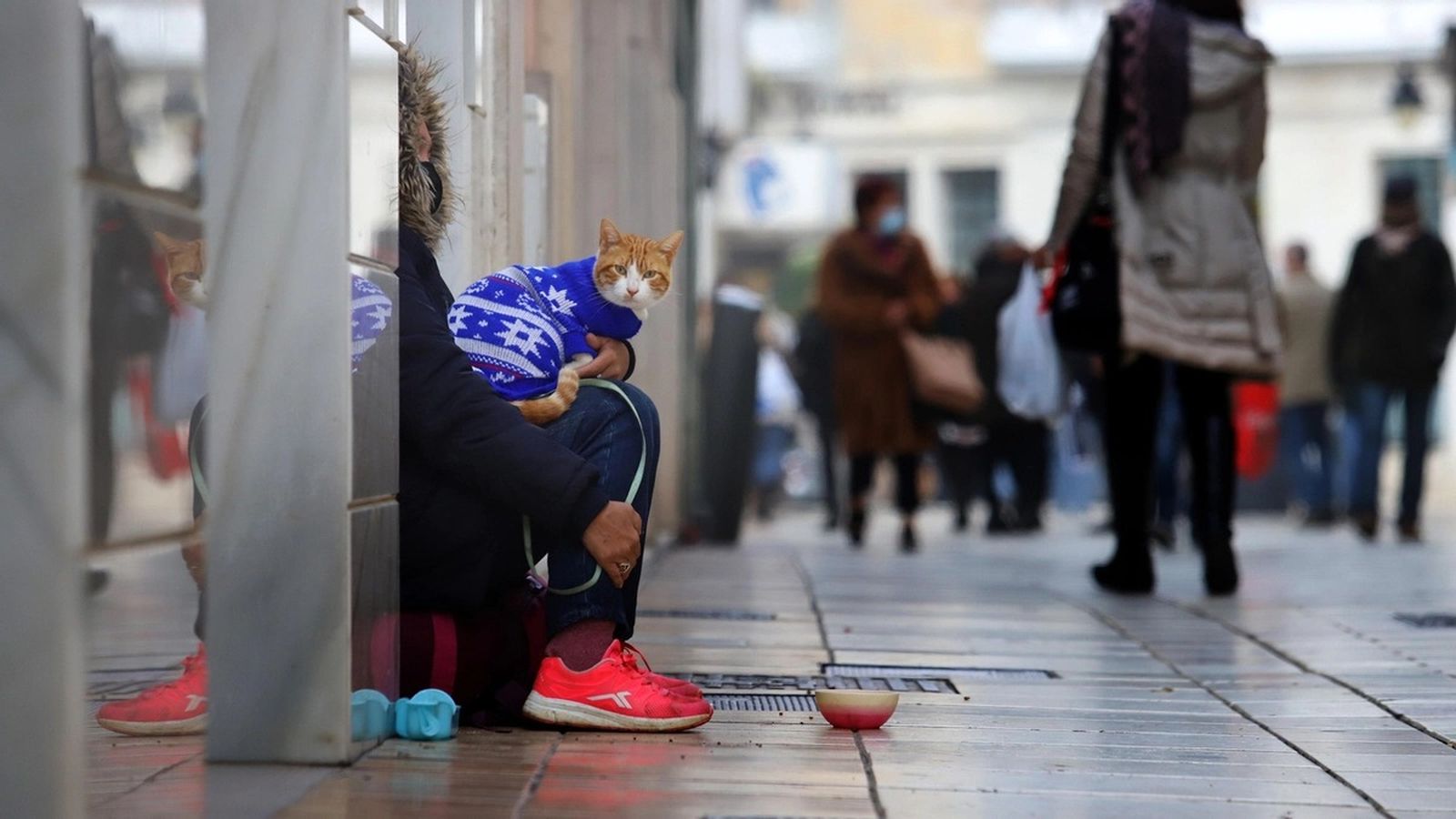 Una persona pide en la calle durante un día de frío.