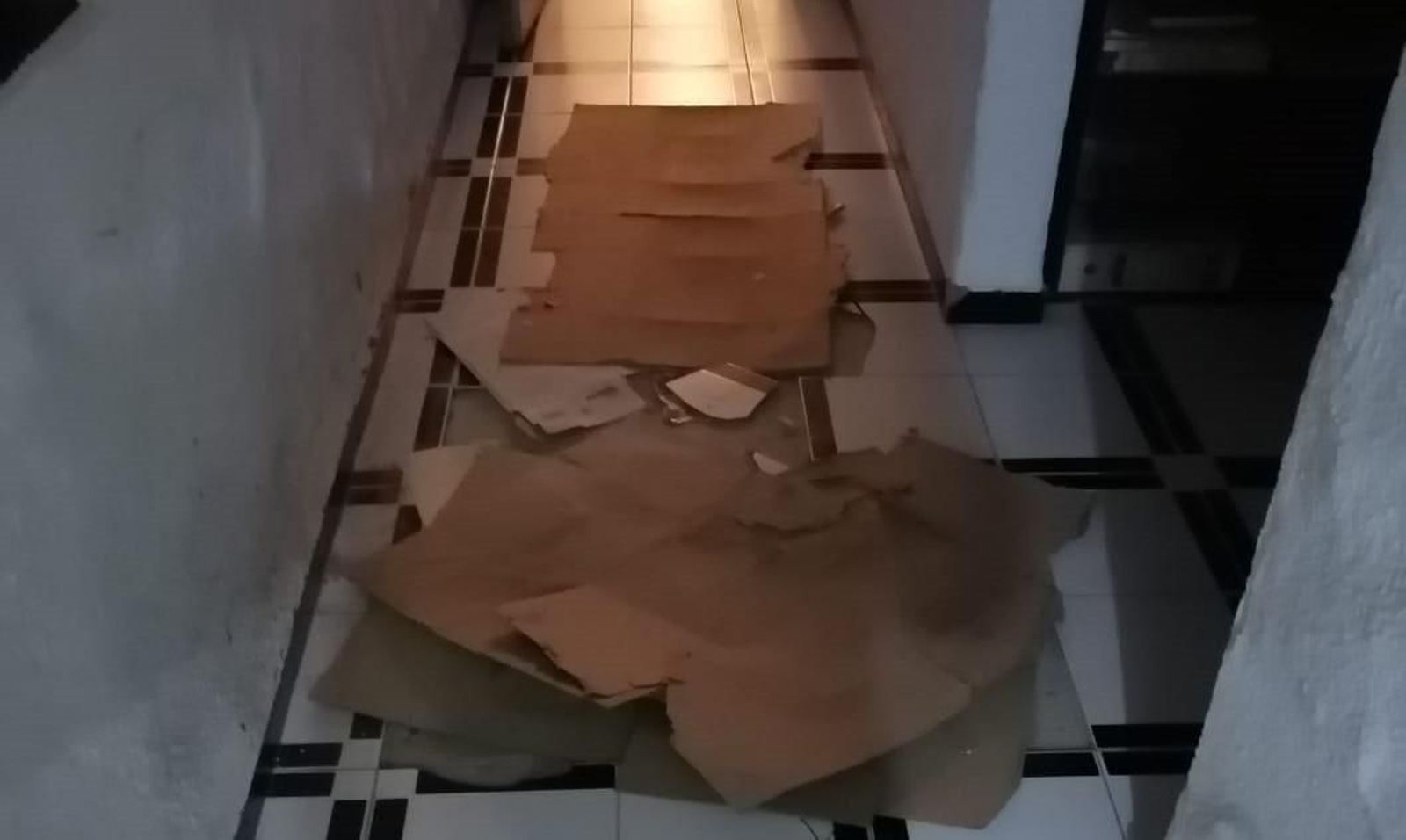 Cartones tapando huecos de baldosas en el antiguo cuartel de la Guardia Civil de Puente Genil.