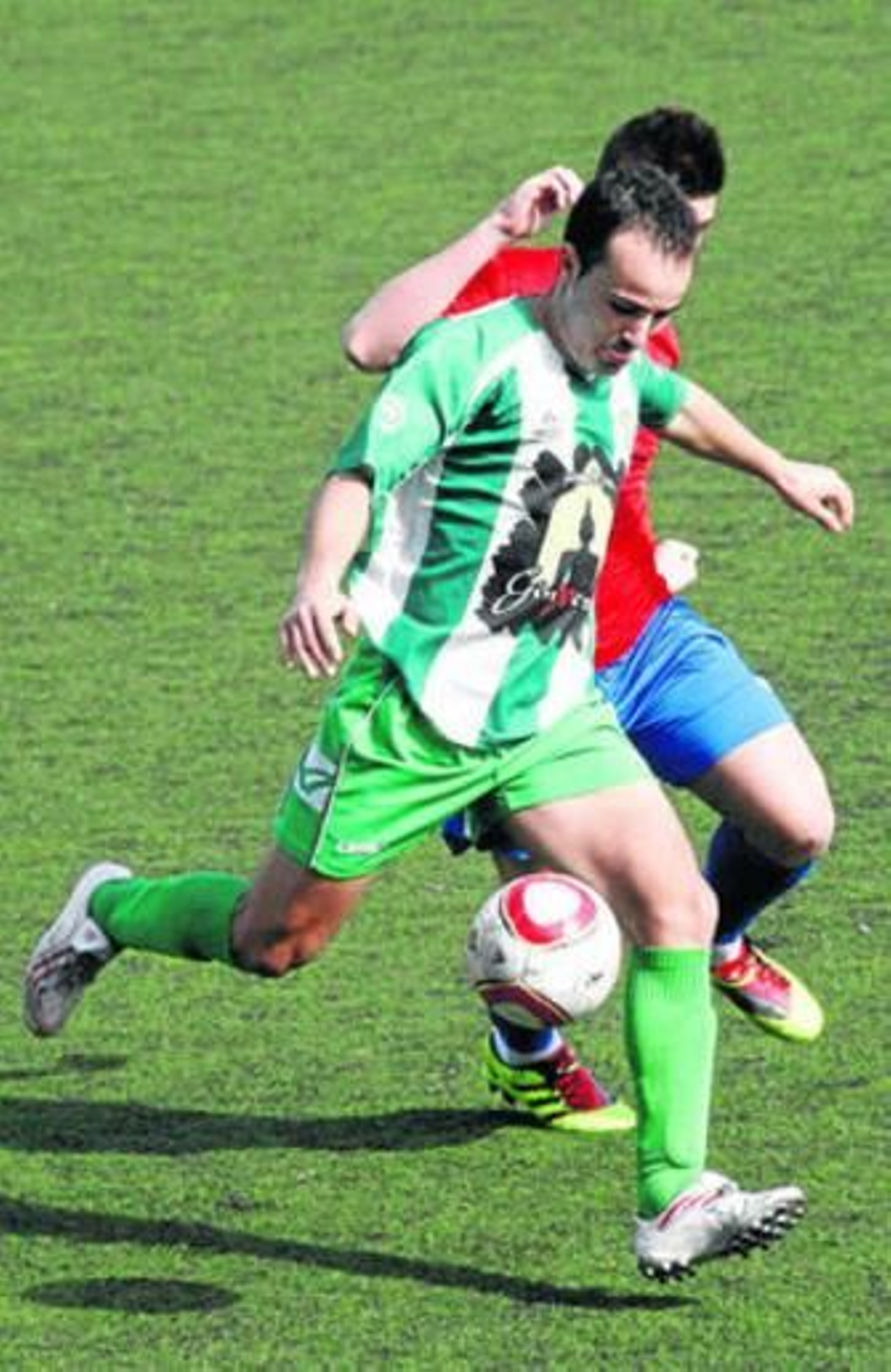 Un jugador vicario conduce el balón ante la presión de un rival.