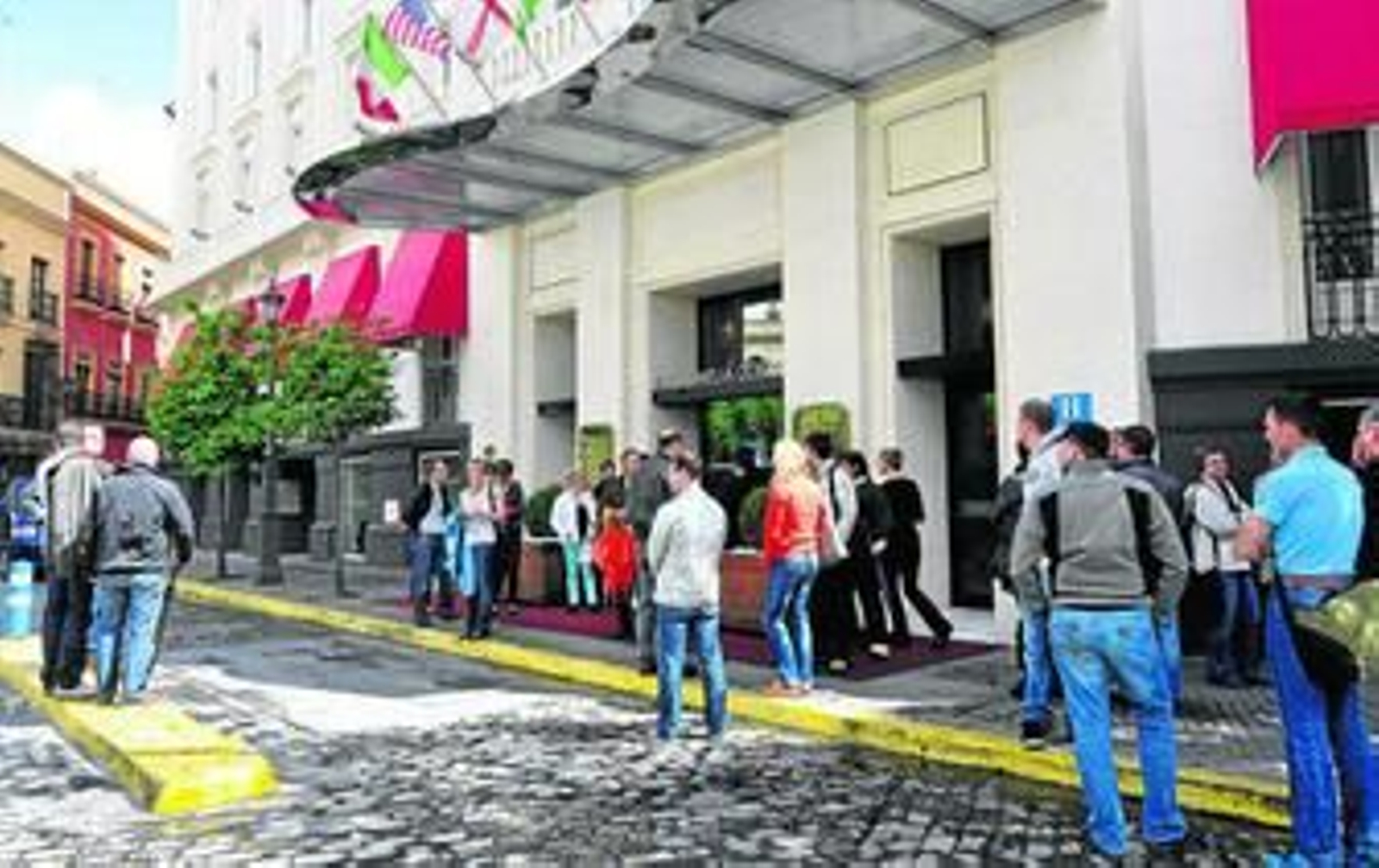 Varios turistas esperaban ayer, domingo de Feria, a las puertas del Hotel Colón.