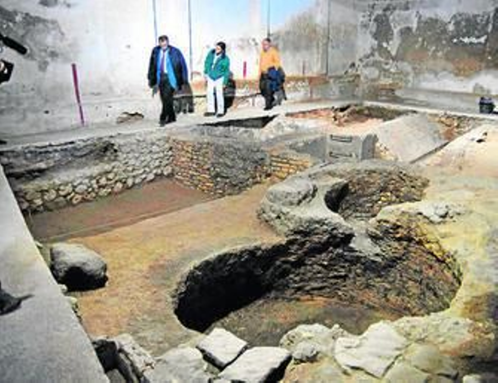 1. El alcalde, José María Román, el delegado de Obras, José Luis Ruiz, y la arqueóloga encargada de los trabajos, Paloma Bueno, hacen un recorrido por las excavaciones en el interior de la nave municipal, donde han aparecido nuevos restos fenicios (en el muro que se aprecia al fondo y a la izquierda), medievales (en forma de cavidades circulares) y romanos (en primer plano a la derecha en forma de pavimento). 2. Restos aparecidos en diferentes momentos de las excavaciones realizadas en el zona. 3. Los operarios del PLES trabajan en la limpieza y clasificación de las piezas encontradas en estas últimas actuaciones./ Fotos: Paco Periñán.