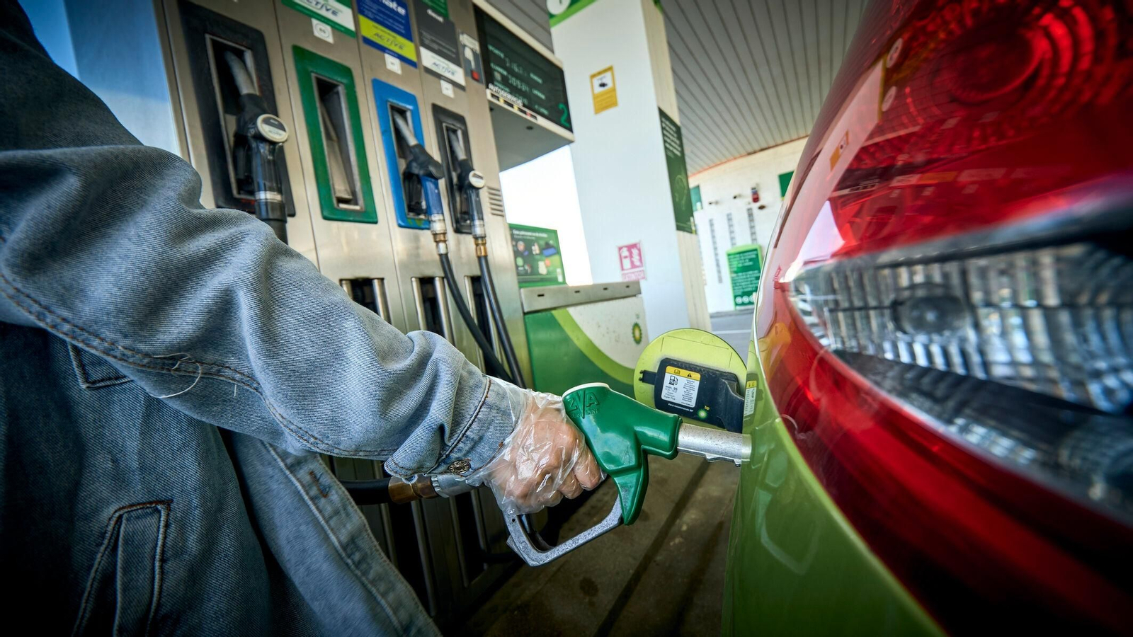 Una persona echando combustible en una estación de servicio.