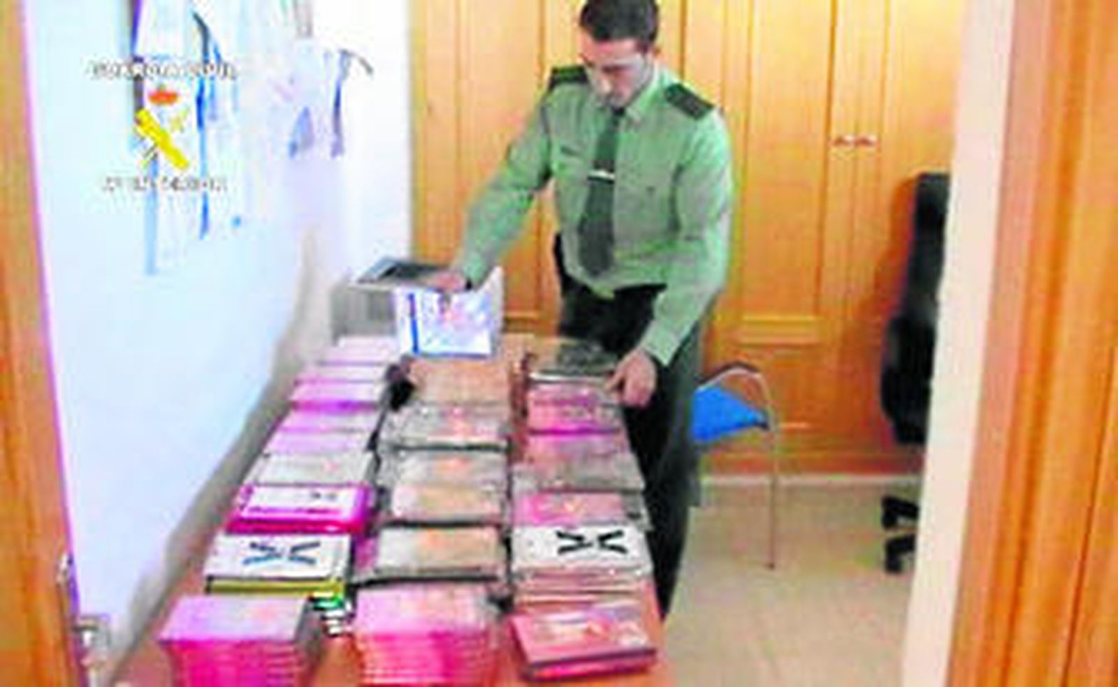 Un agente revisa el material pornográfico intervenido en la tienda.