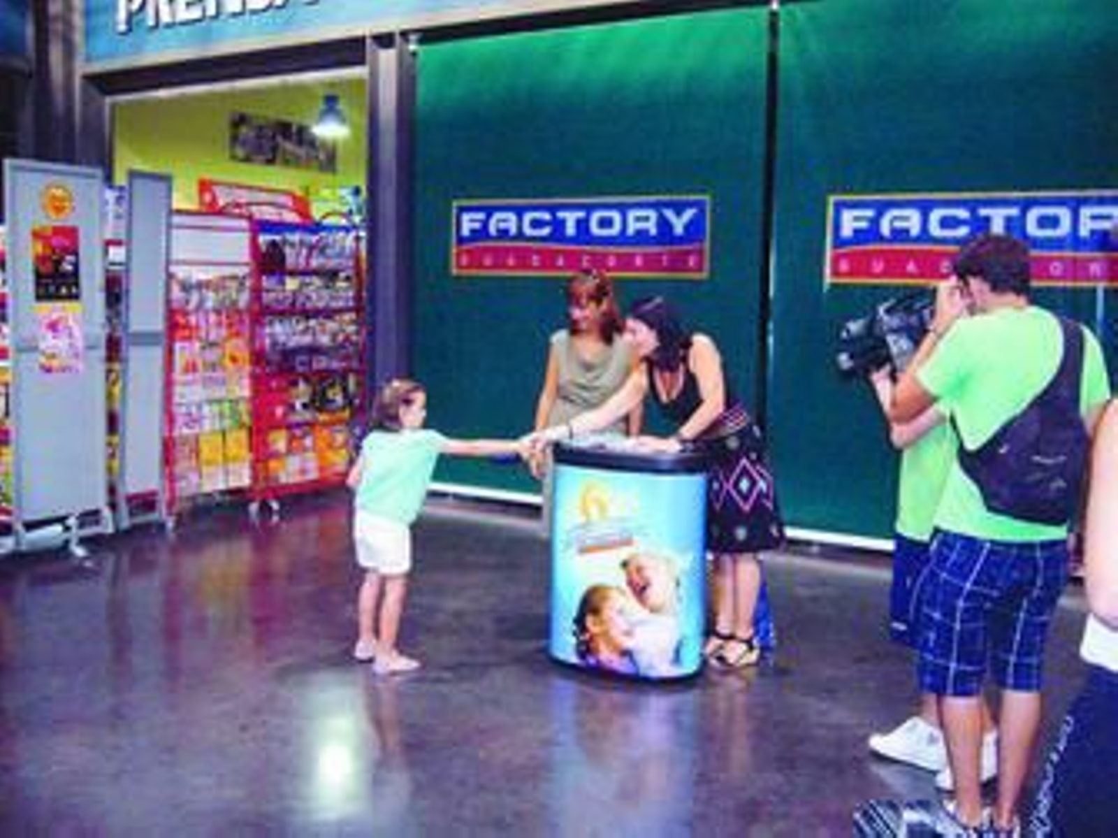 Una niña recibe su cartilla de ahorros durante la campaña de Factory Guadacorte.