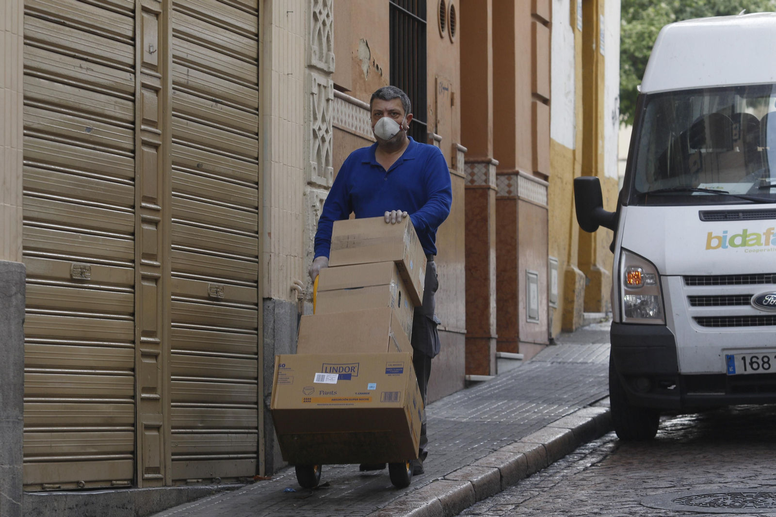 Un trabajador descarga material de primera necesidad en una farmacia del centro.