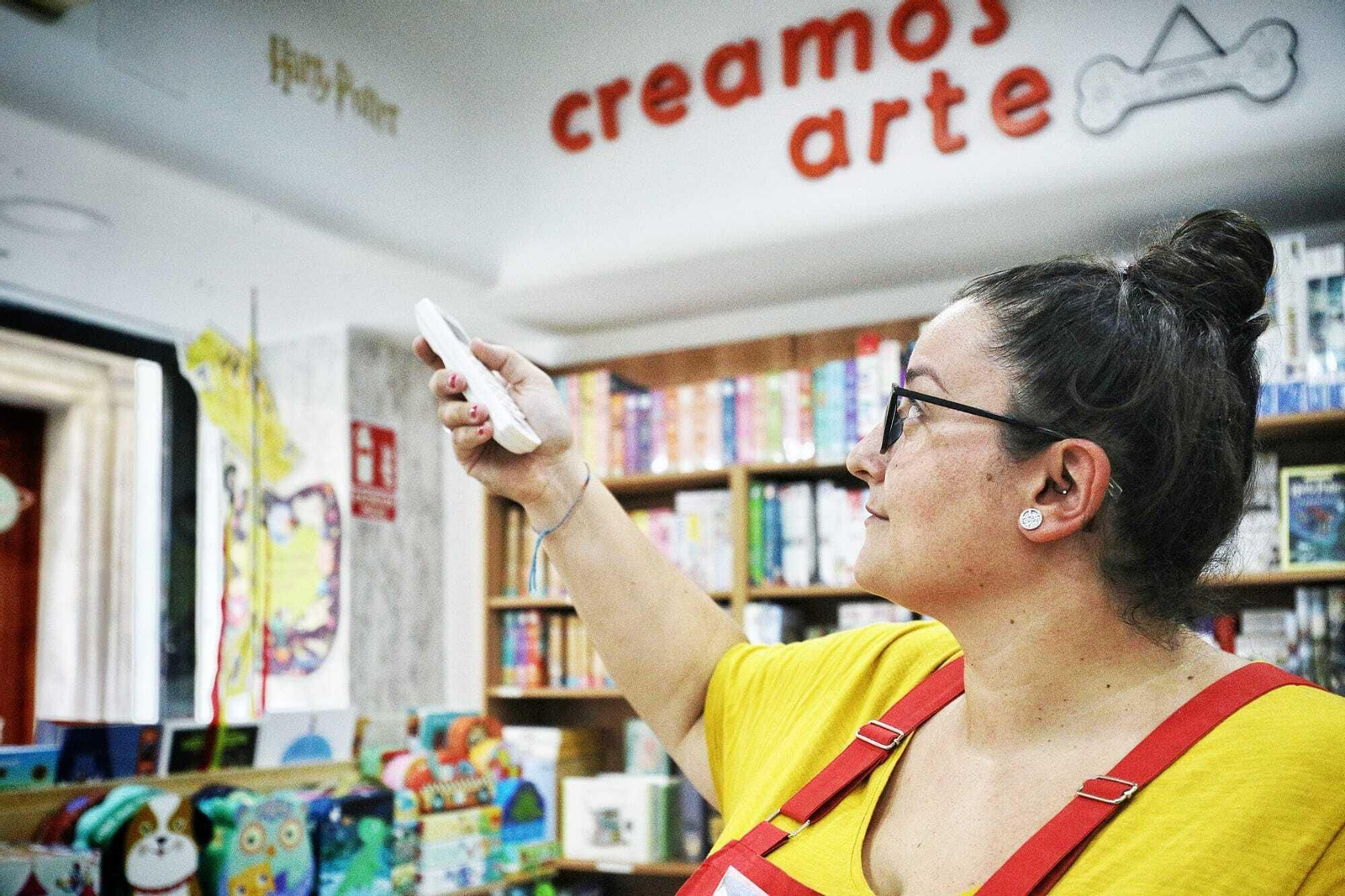 La empleada de una librería regula la temperatura del aire acondicionado.