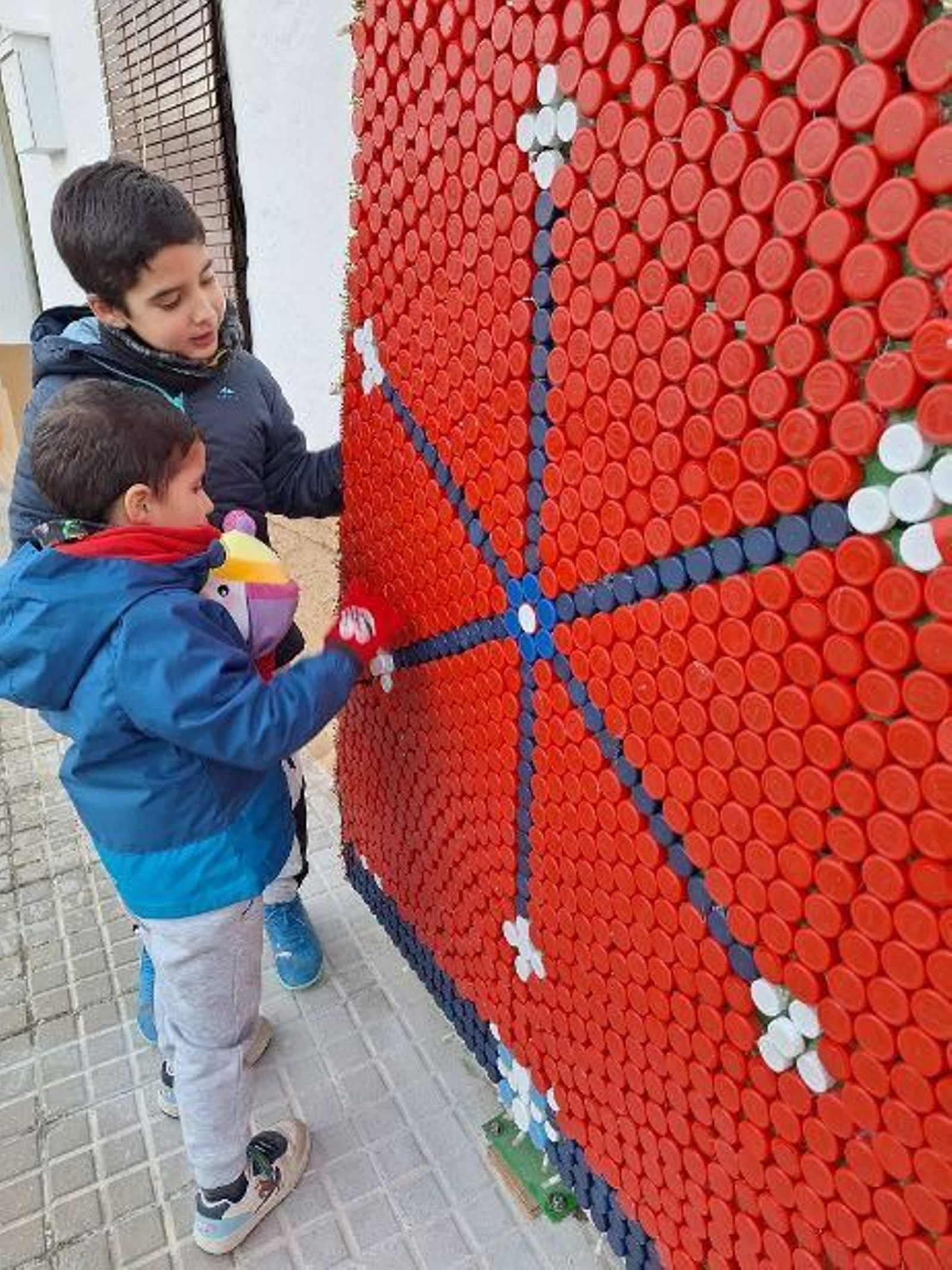 Dos niños ultiman la decoración de un motivo navideño en Sotogordo.