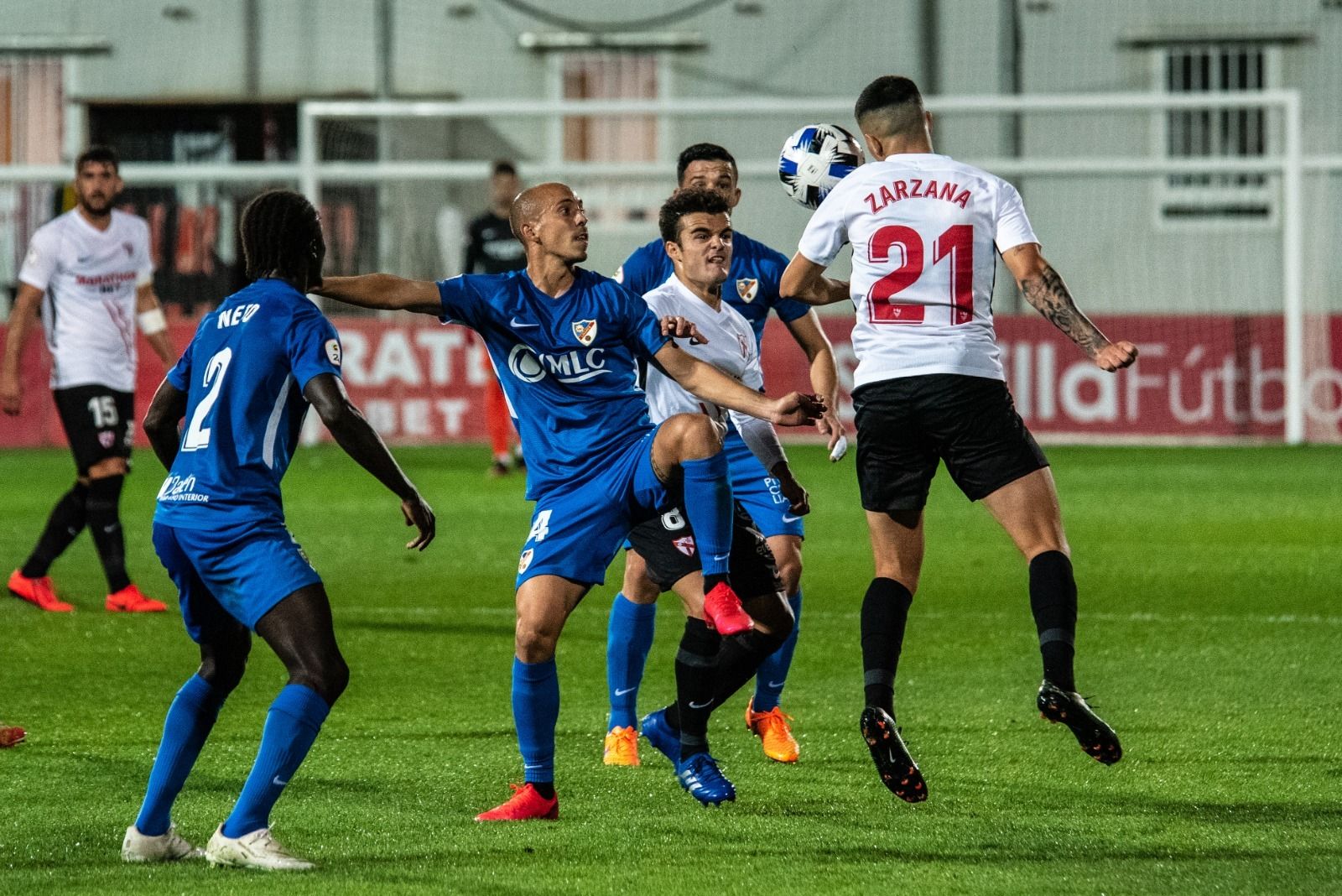 Zarzana cabecea un balón ante dos jugadores del Linares.