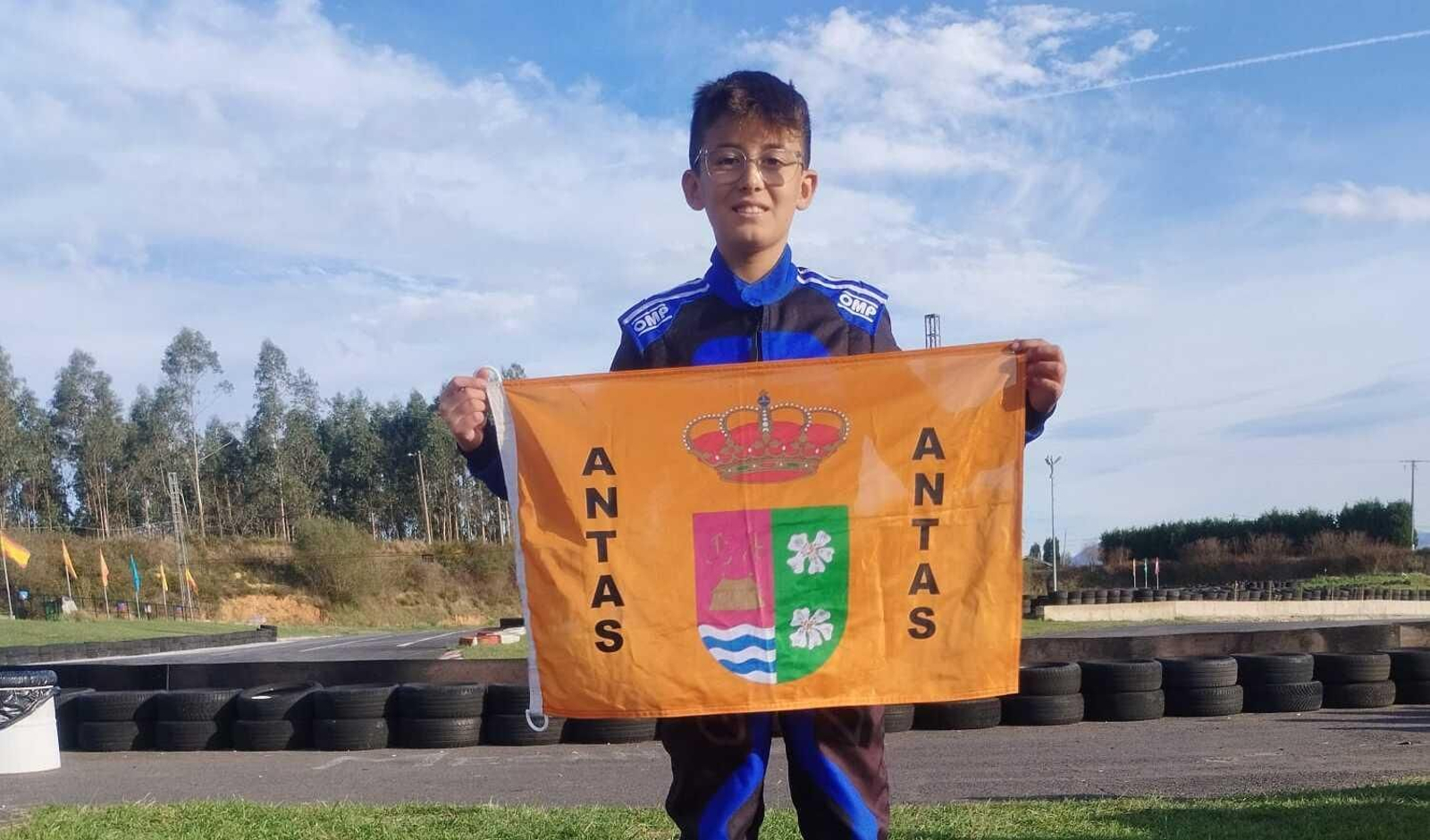 El piloto almeriense posa con la bandera de Antas después de su participación en la prueba asturiana.