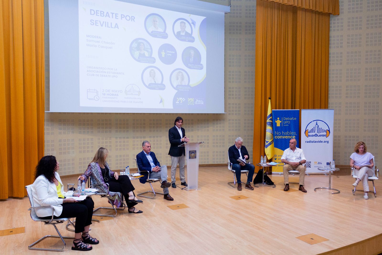 Los seis candidatos a la Alcaldía durante el primer debate de campaña celebrado en la Universidad Pablo de Olavide.