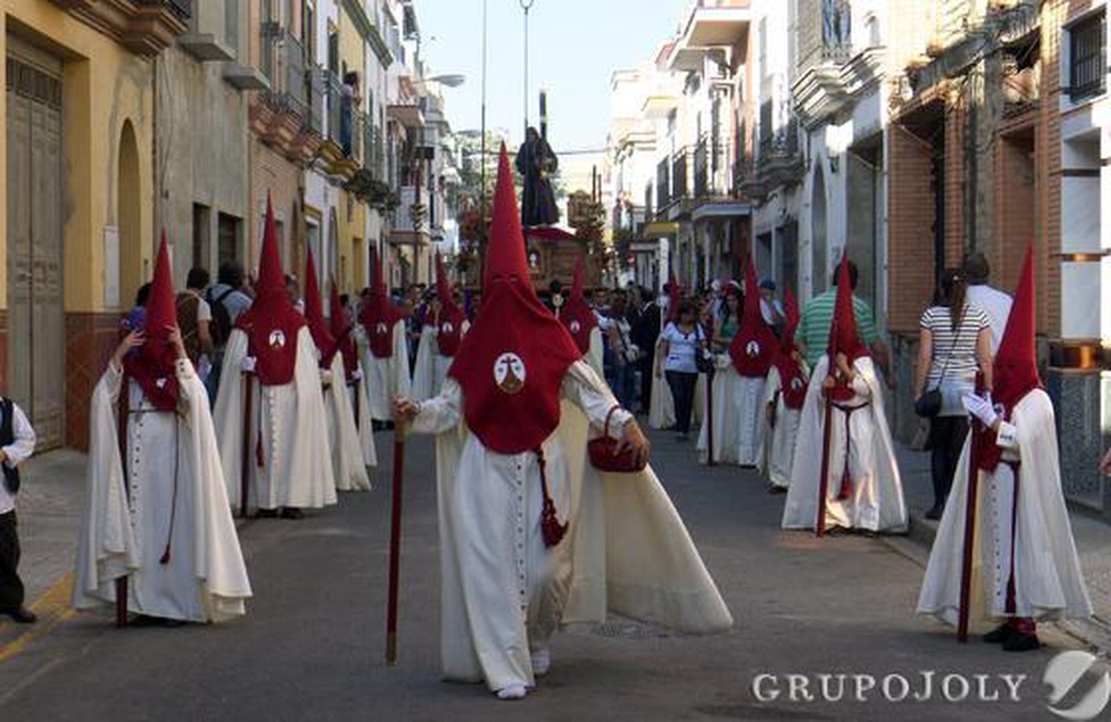 Nazarenos con el paso de misterio detrás por las calle del barrio.

Foto: Juan Carlos Muñoz