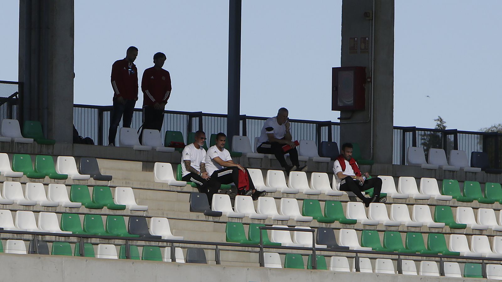 Jon Pascua, sentado con gafas junto un compañero, en las gradas de la ciudad deportiva.