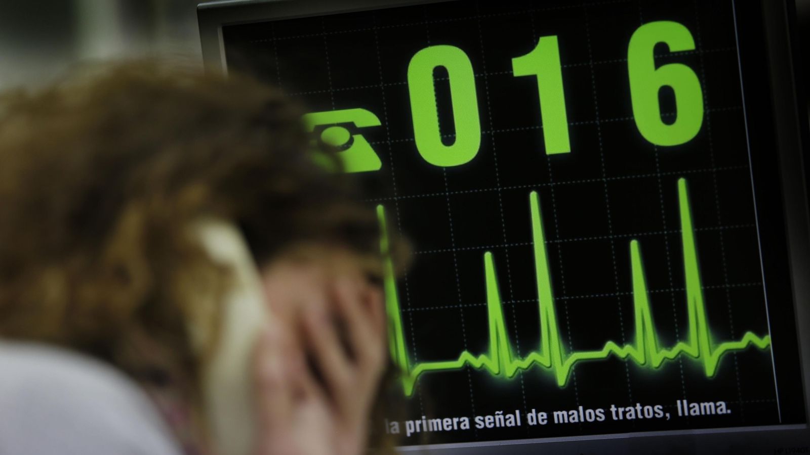 Una pantalla muestra el 016, número de teléfono para denunciar la violencia  de género.