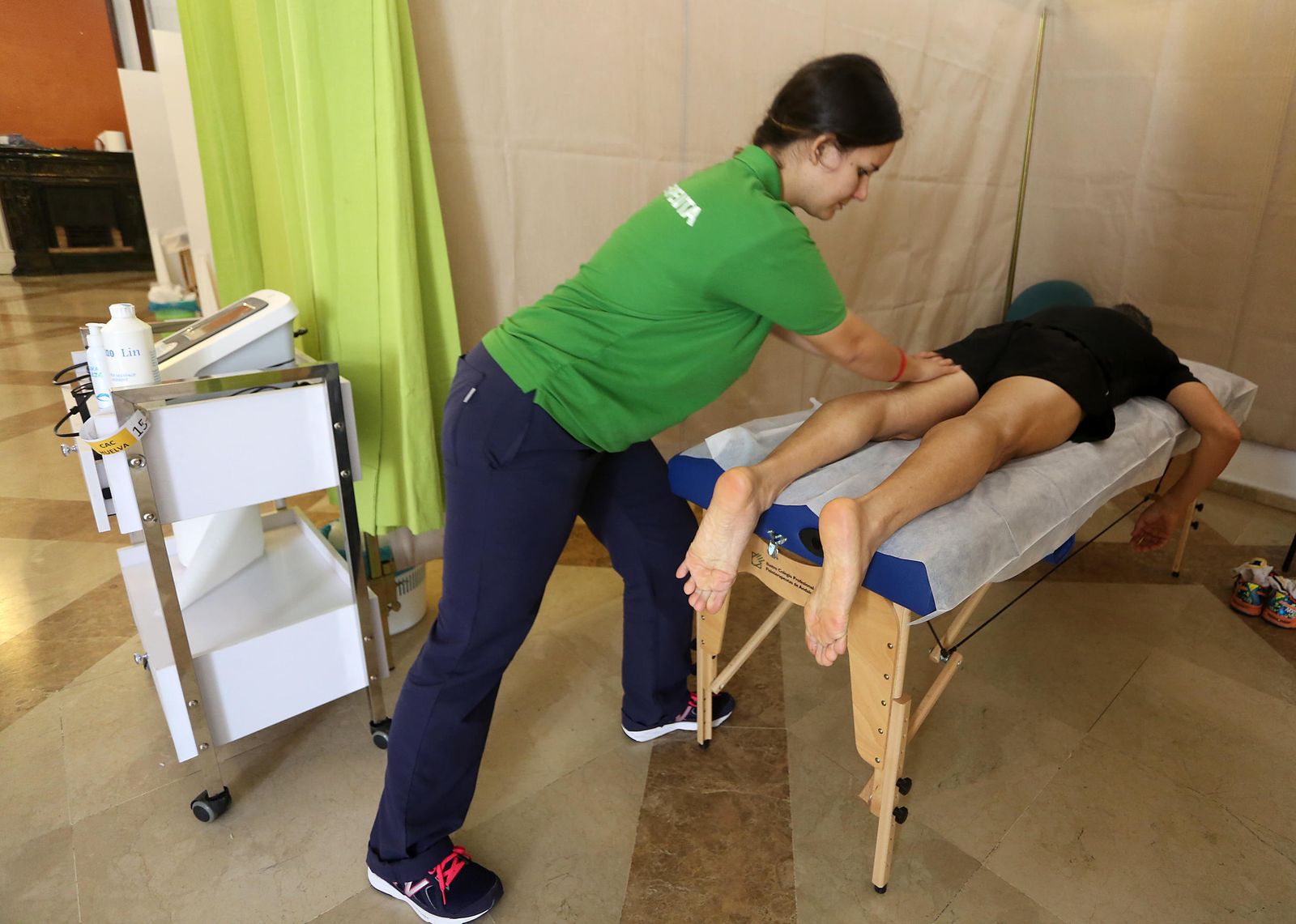 Un costalero recibe un masaje en las piernas en el Centro de Atención.