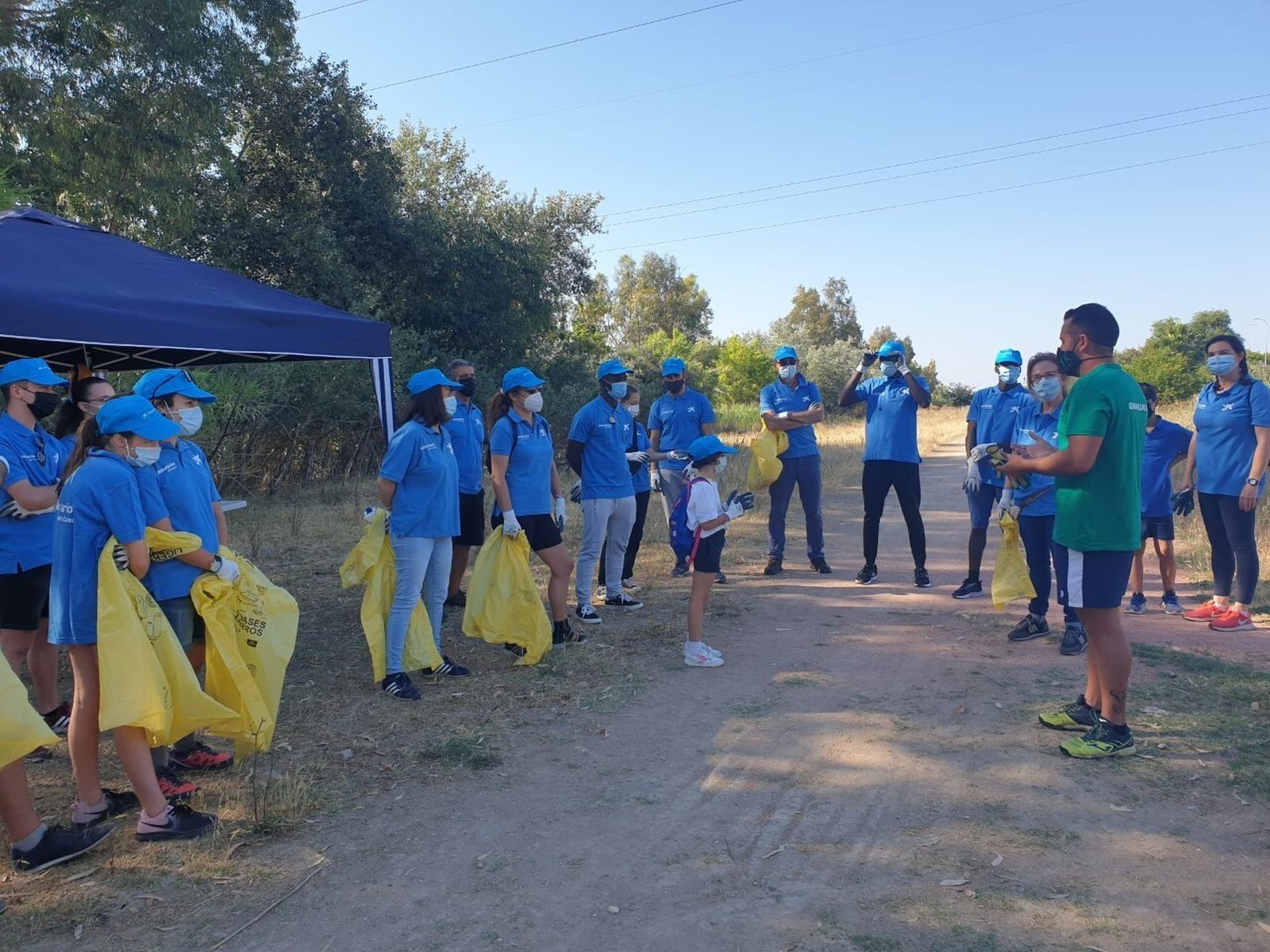 Voluntarios de Caixabank recogen residuos junto al Guadalquivir.