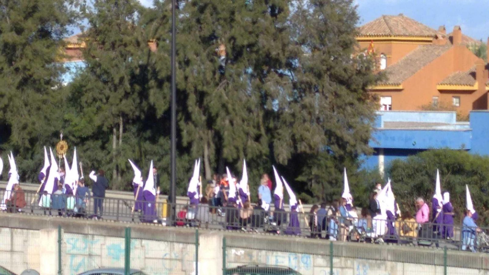 Hermanos del Gran Poder por el puente a la ida de la Carrera Oficial.