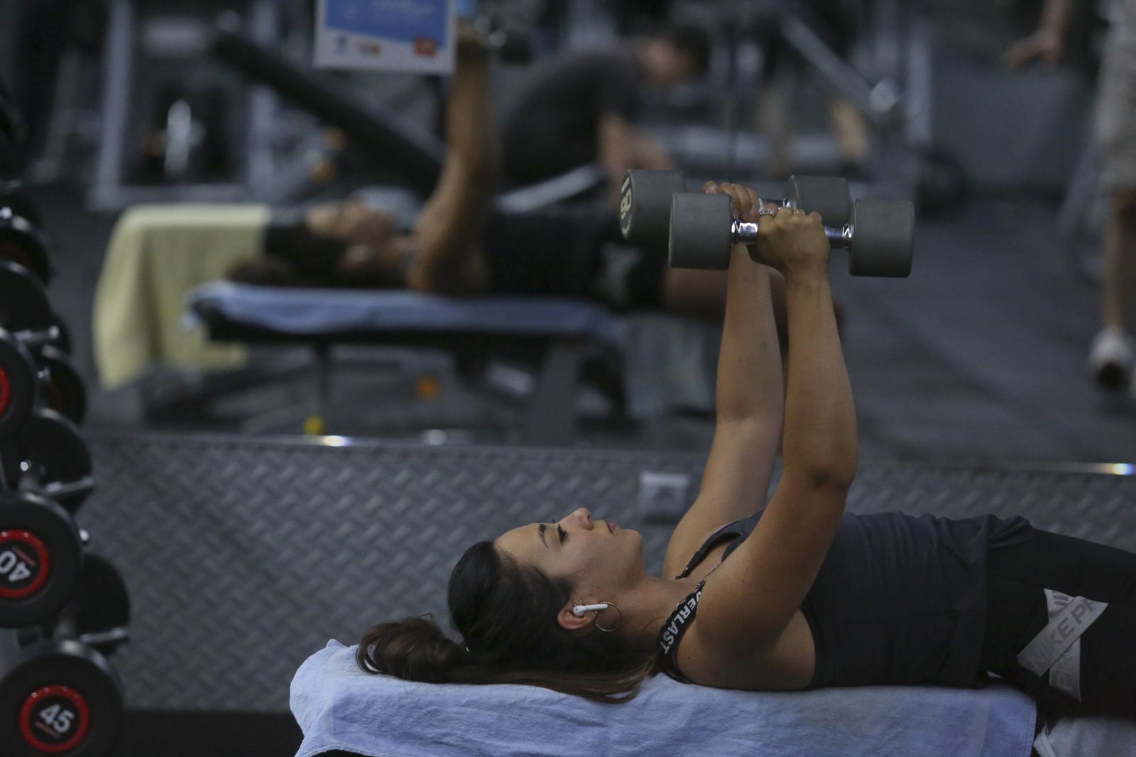Una chica haciendo pesas en el gimnasio.