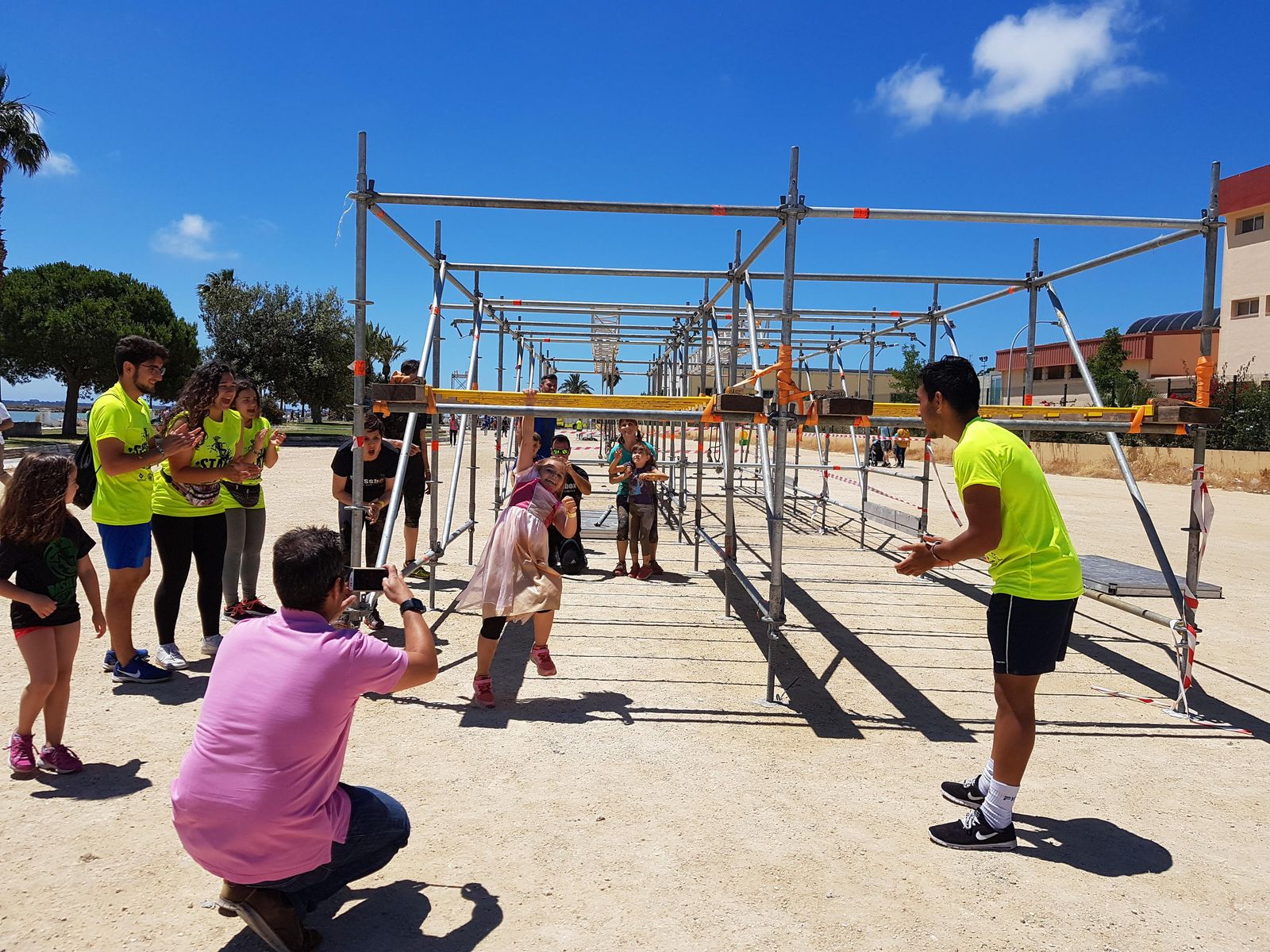 Una pequeña salva el obstáculo de las anillas con el ánimo de sus padres y los voluntarios de la cita.