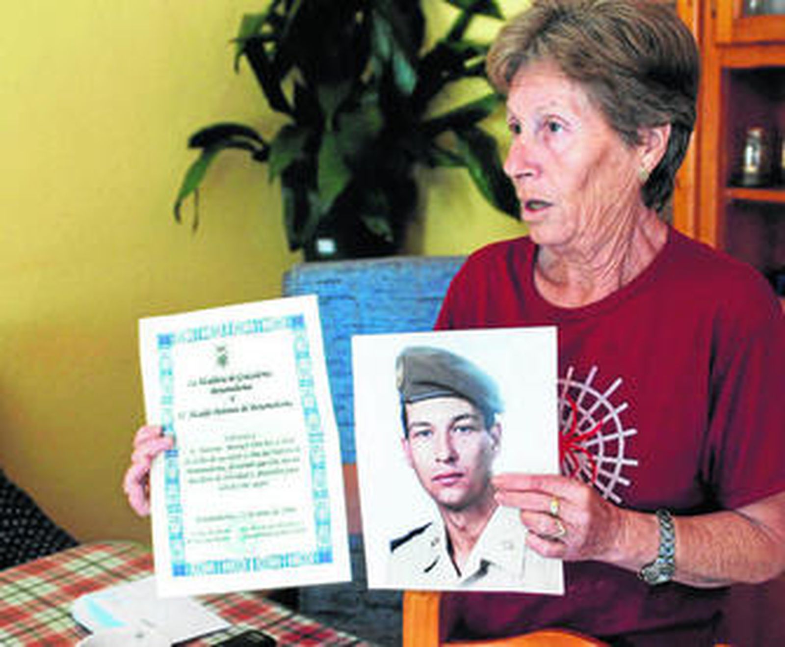 Antonia sostiene una foto de su hijo de militar y una felicitación de cumpleaños del alcalde de Grazalema.