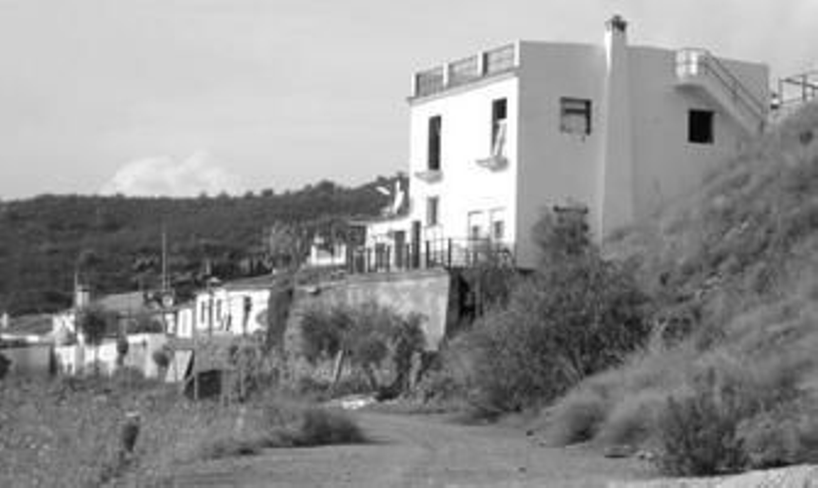 En primer plano, una de las viviendas que ayer fueron precintadas por los agentes de la Policía Autonómica.