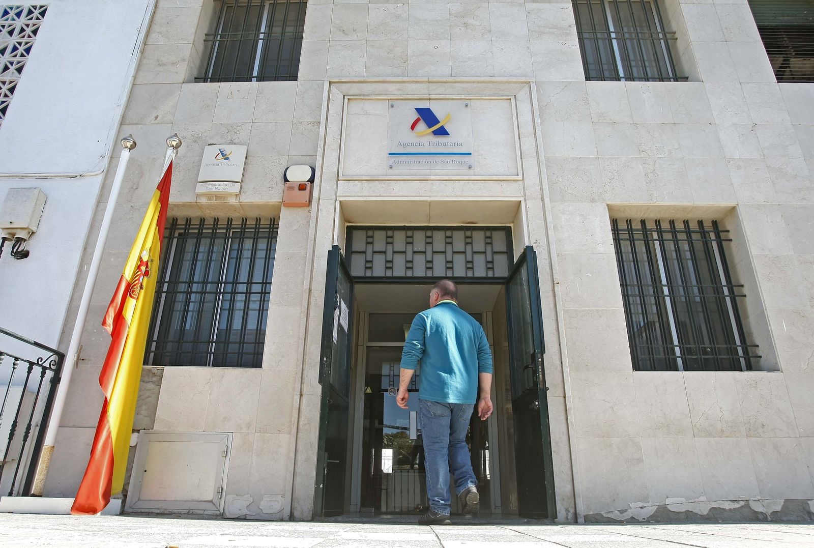 Una mujer firma para evitar el cierre de la oficina en un establecimiento de La Alameda, ayer.