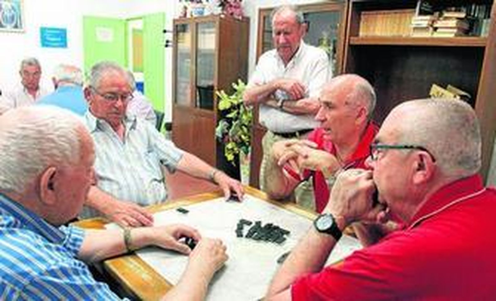 Juan Correa, Adolfo Rey, Esteban Gil y Eugenio Quero conversan sobre política mientras juegan al dominó.