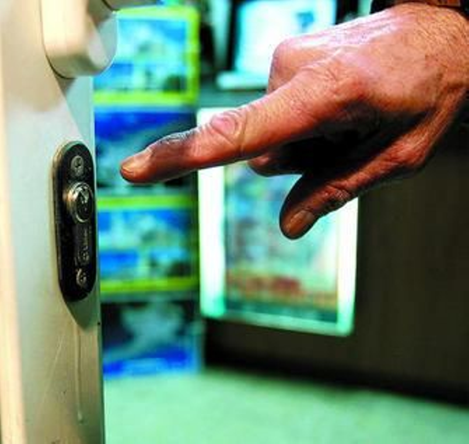 Un comerciante señala la cerradura saboteada de su tienda, aún con restos de pegamento.