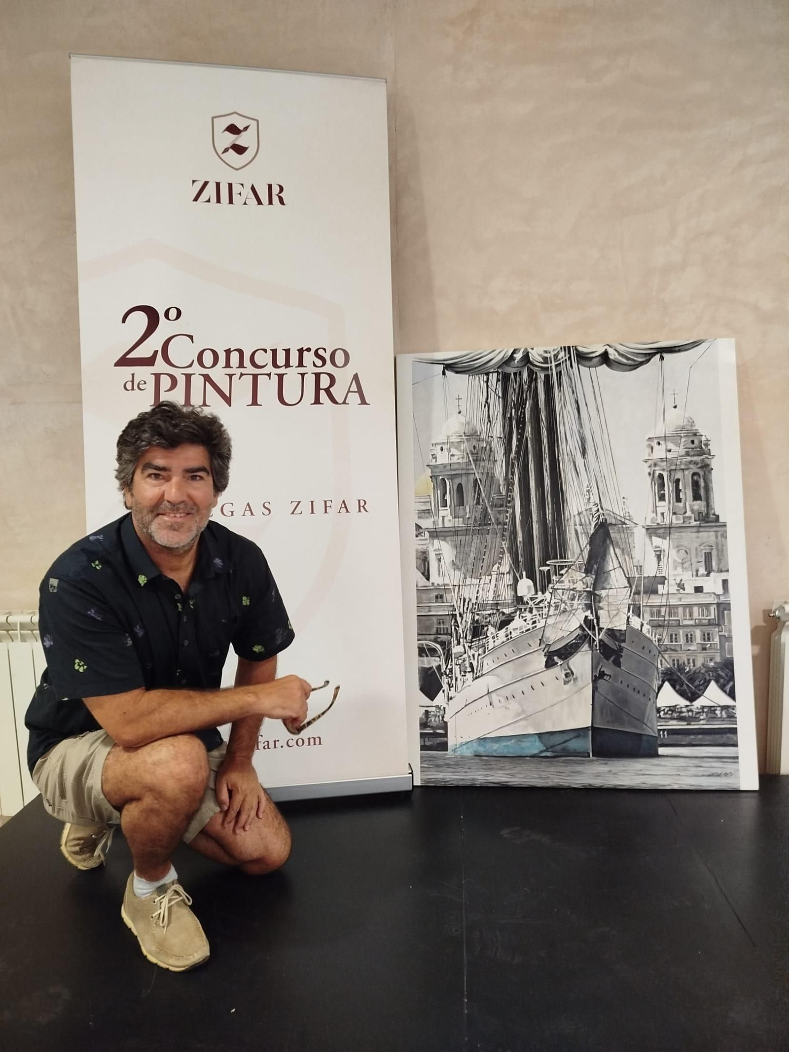 Fernando Lores junto a su obra 'Marcando Rumbo, Haciendo Historia' durante la recogida del premio.