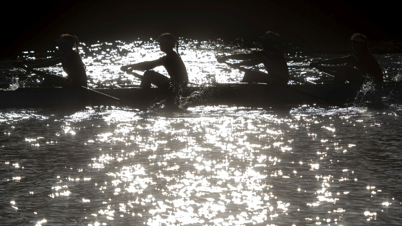 Varios deportistas practican remo.
