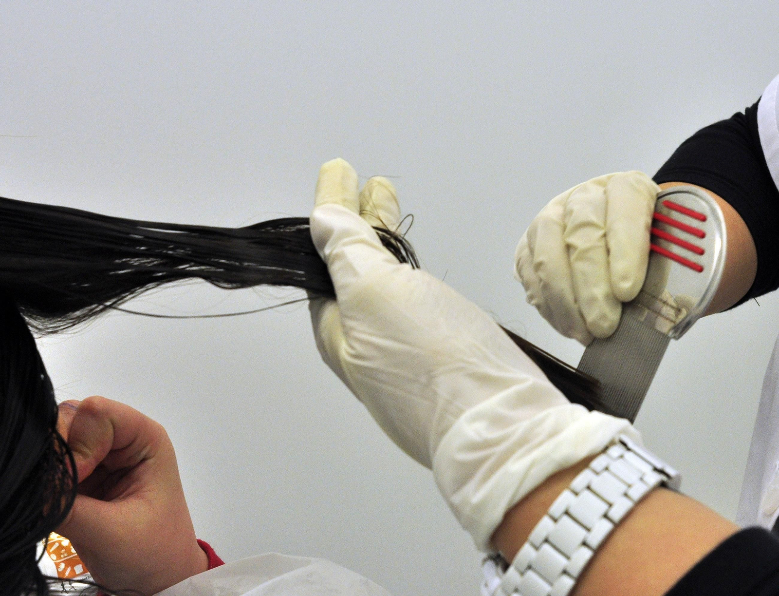 Una peluquera peina el cabello recién lavado de una clienta.