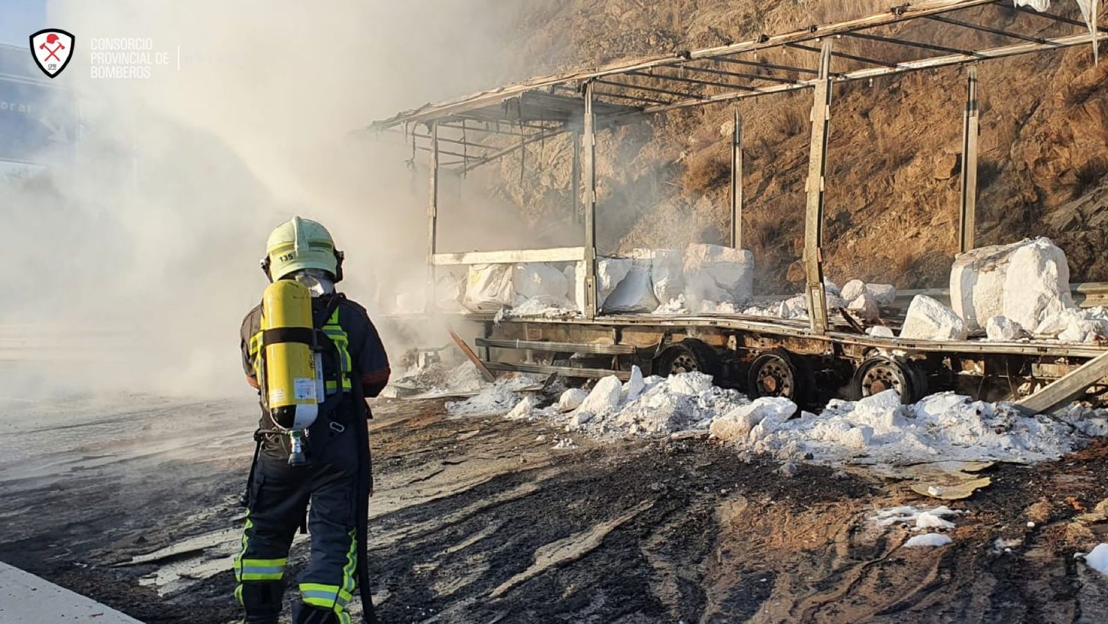 Un bombero del Consorcio Provincial en las labores de extinción del camión siniestrado.