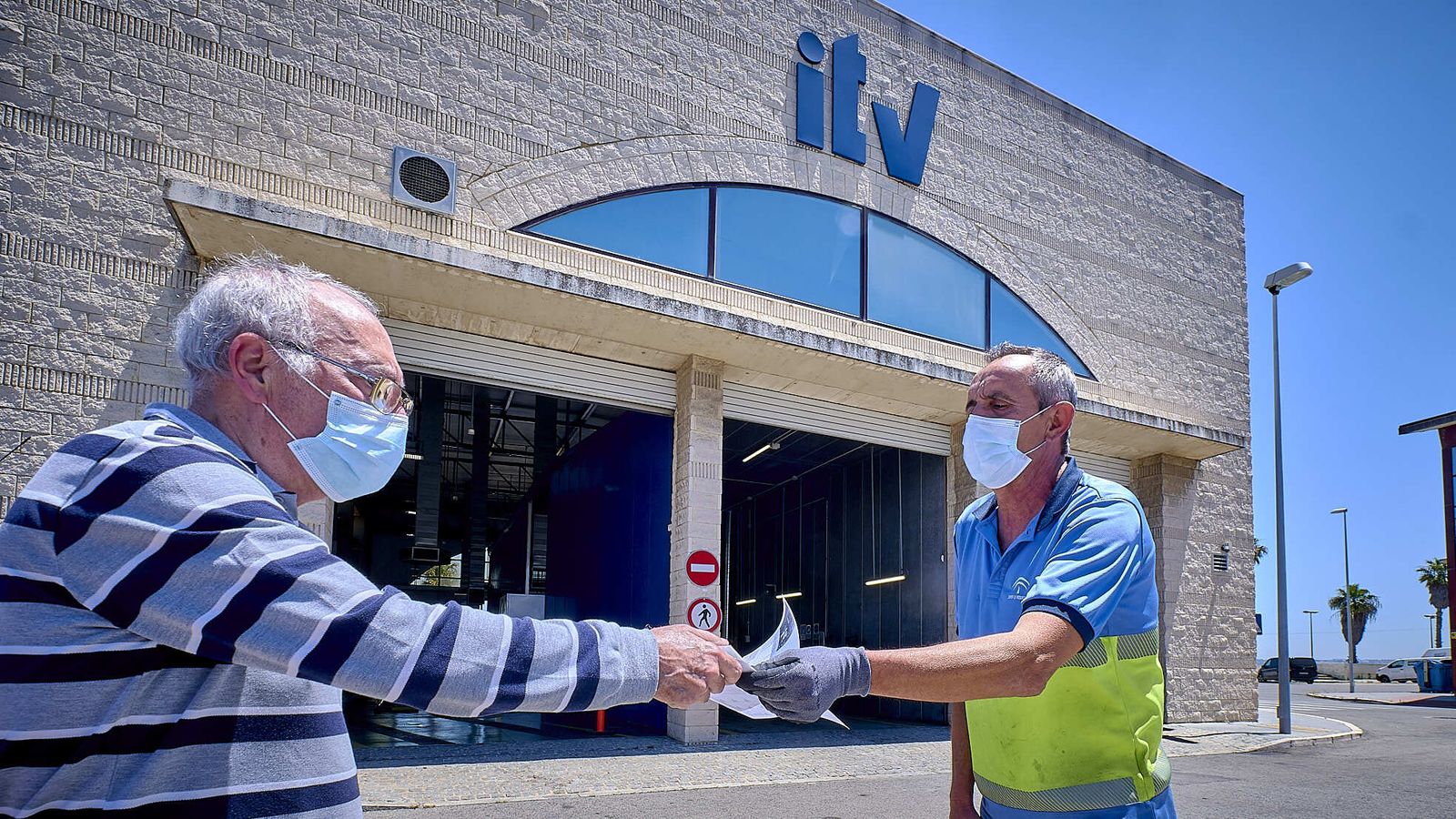 Un operario de la ITV de Cádiz entrega un documento a un conductor.