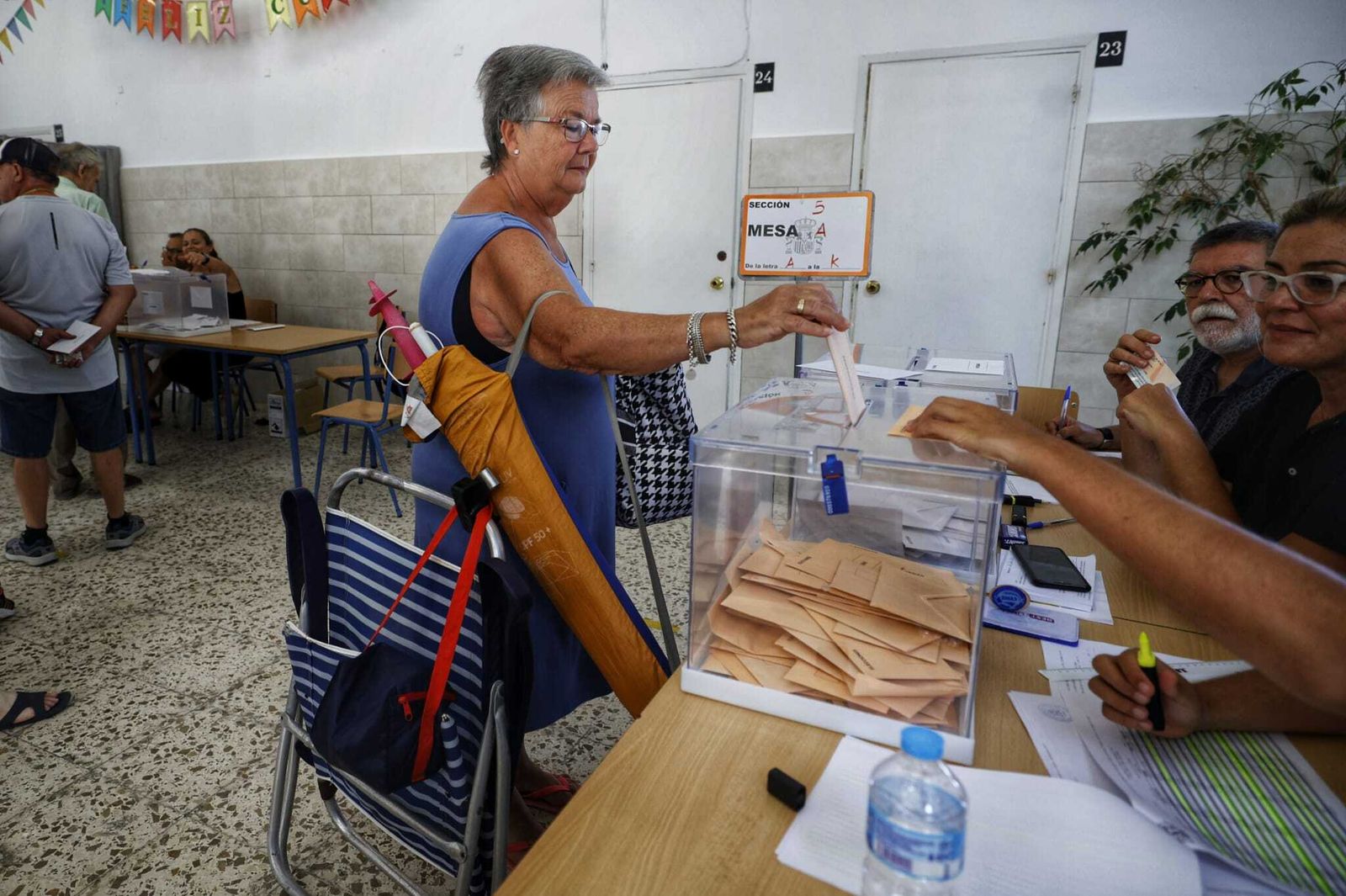 Una mujer vota en Cádiz el domingo antes de ir a la playa.