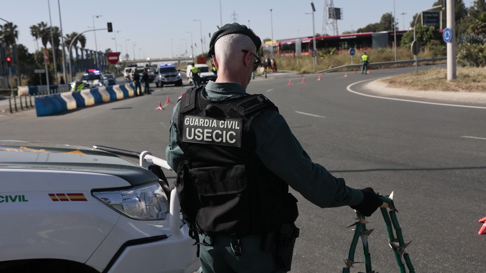 Un agente prepara la cadena de pinchos para inmovilizar vehículos.