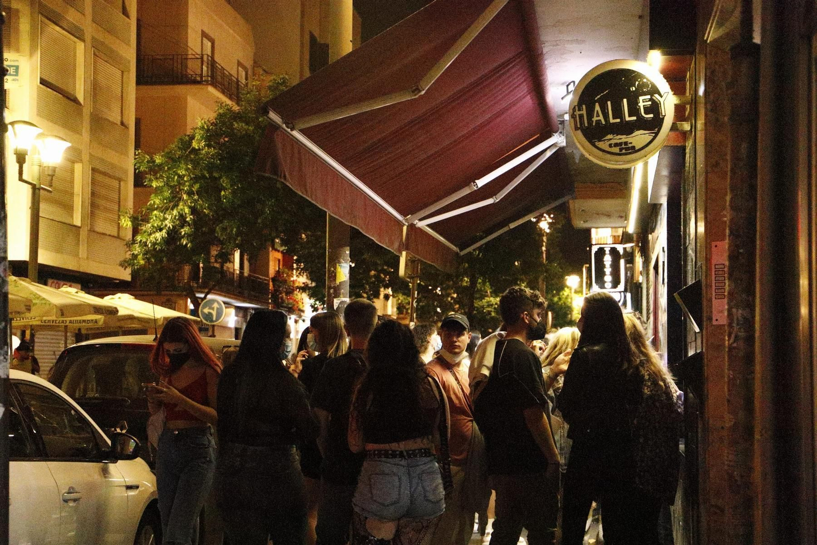 Un grupo de jóvenes espera en la puerta de un establecimiento de copas en Granada.