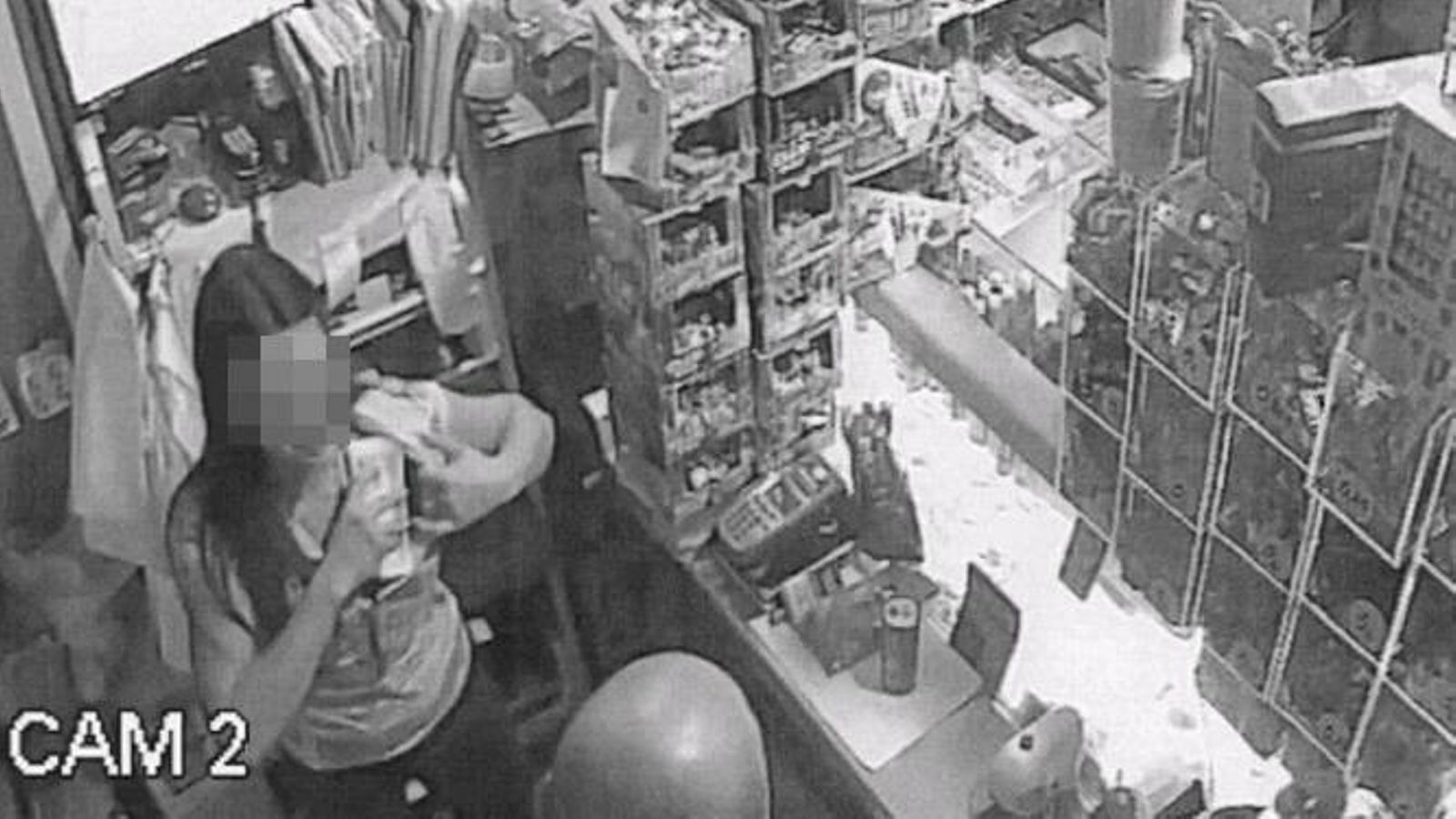 Una mujer no identificada se guarda fajos de billetes.