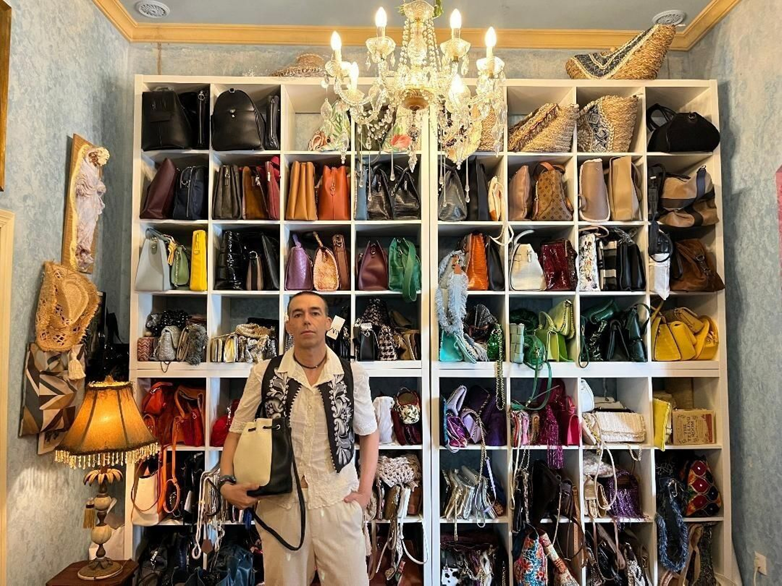David Calleja, delante de un mueble expositor con numerosos bolsos de diferentes colores  que le da tonalidad al conjunto.