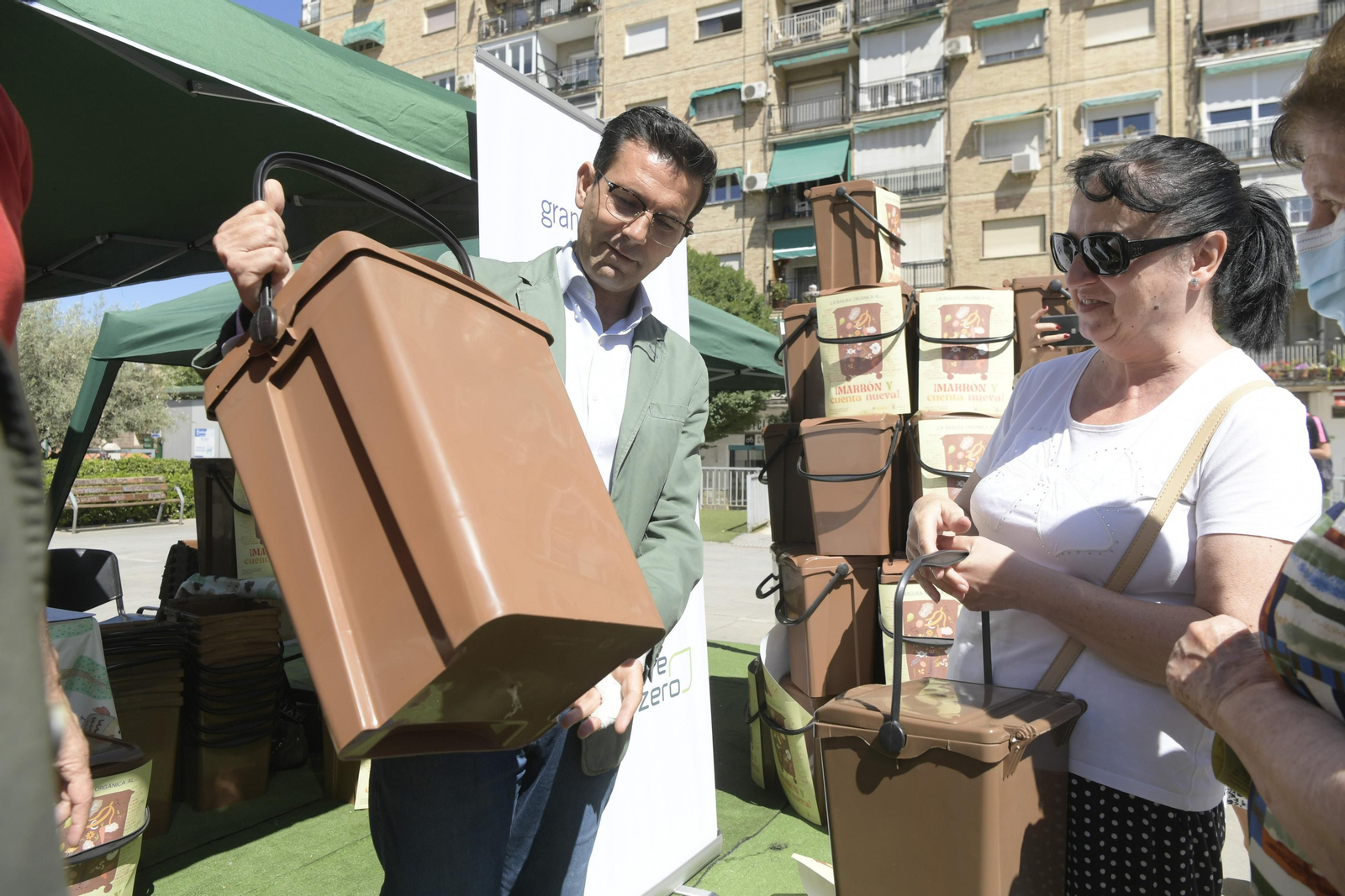 El alcalde de Granada, Francisco Cuenca, entrega un contenedor marrón especial para viviendas a una vecina