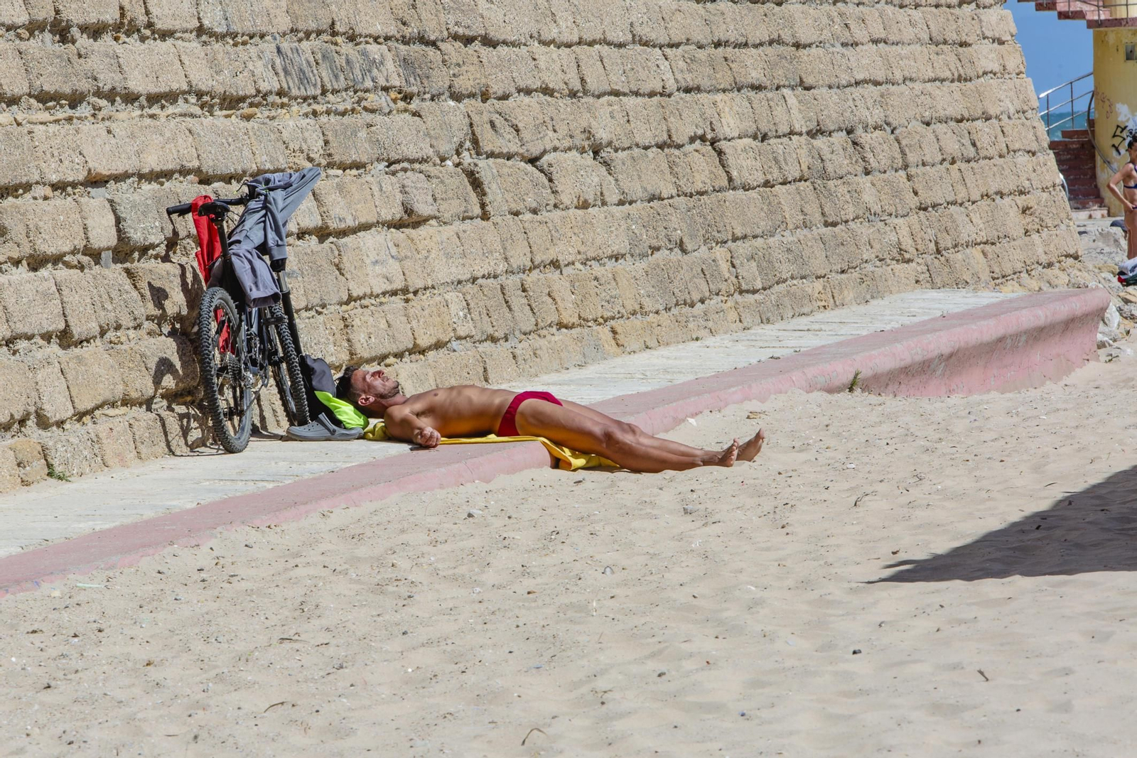 Un bañista disfruta del sol, esta tarde, en Santa María del Mar.