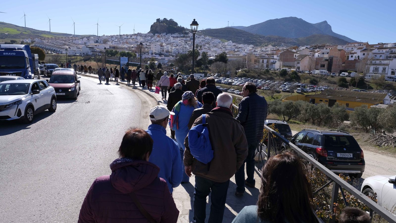 Visitantes llegando a Ardales tras aparcar sus vehículos fuera del casco urbano.