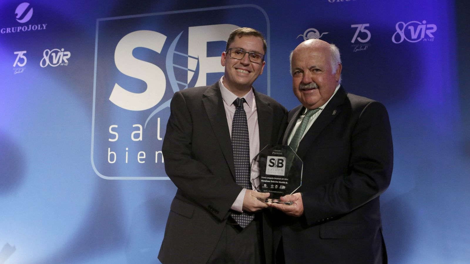 El consejero de Salud, Jesús Aguirre, entrega el premio a Miguel Carrillo, de Masqsano Tech.