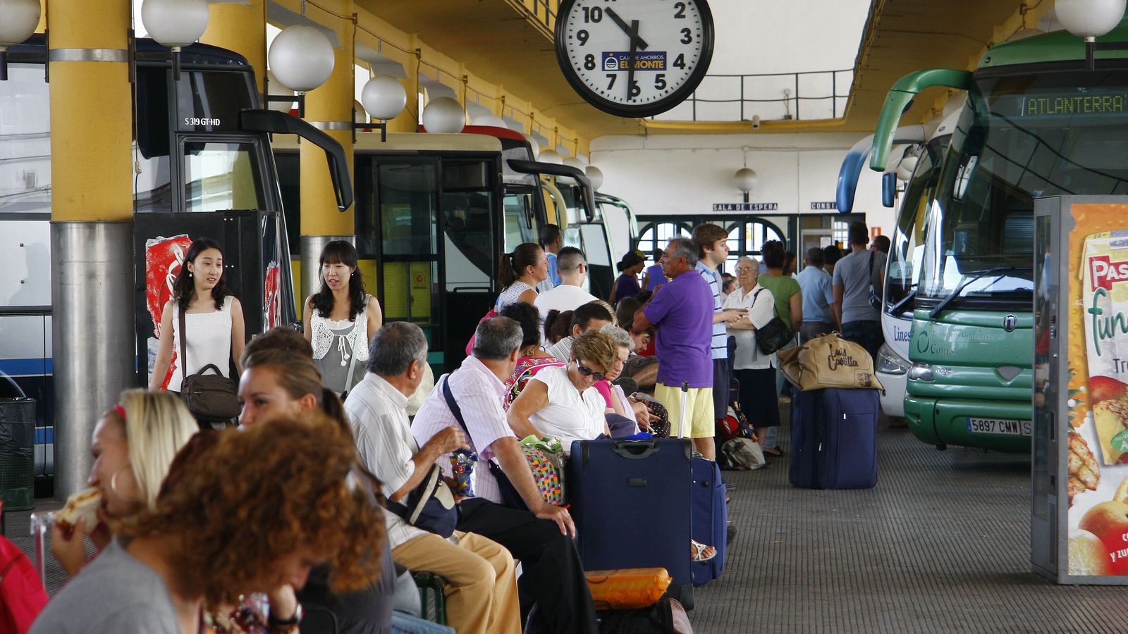 Viajeros esperan en la estación de autobuses del Prado.