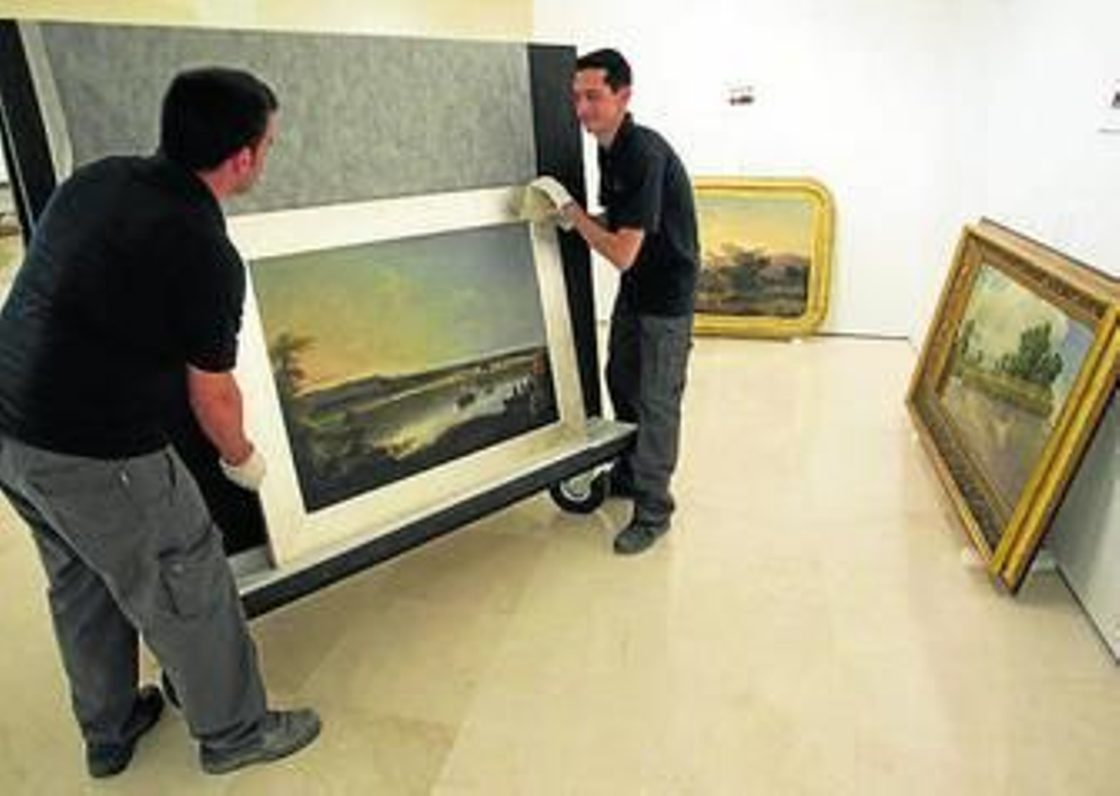 Dos operarios trasladaban ayer uno de los cuadros de la exposición.