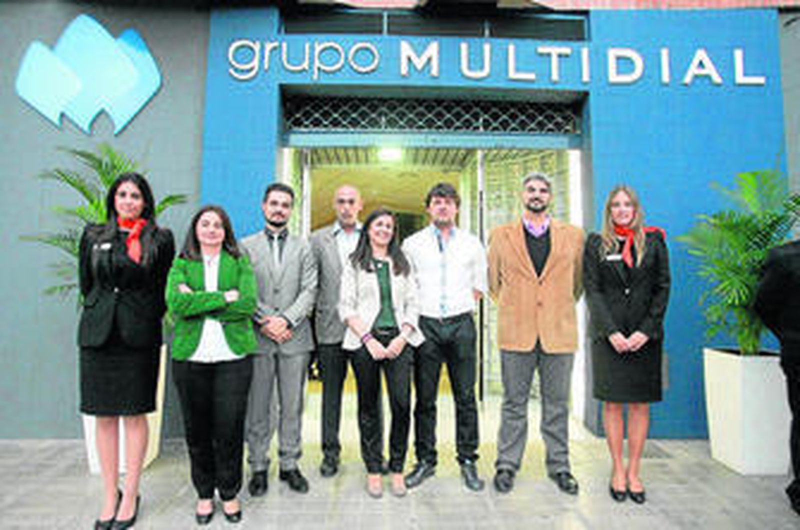 El grupo humano que conforma la columna vertebral de Grupo Multidial junto a la puerta de sus instalaciones.